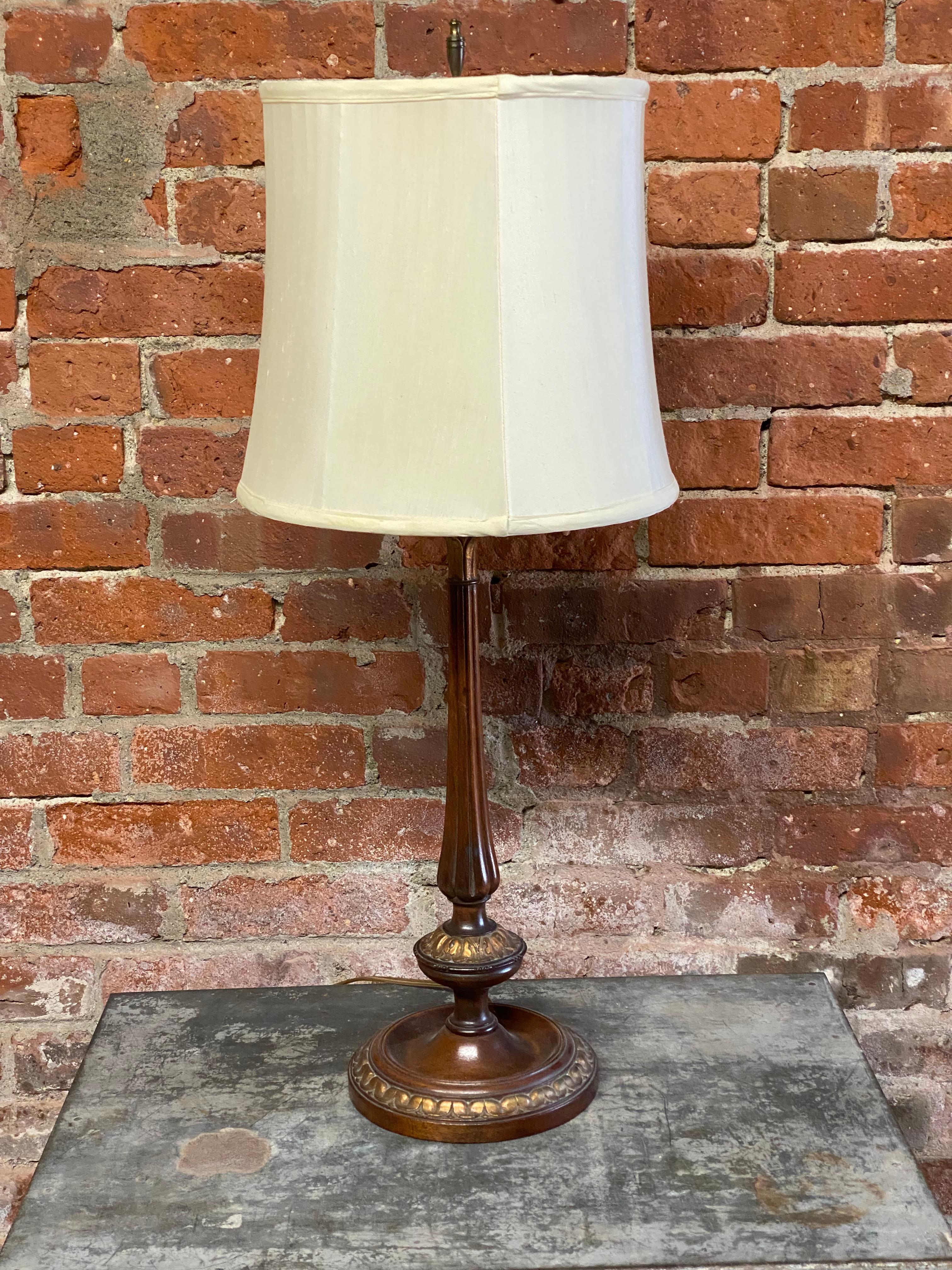 A gorgeous carved and parcel gilt walnut table lamp. Circa 1920-30. Purchased at Bloomingdale's, New York City by the original owner. This delicate beauty bares all the quality of fine furniture making and lighting being sold at some of New York's