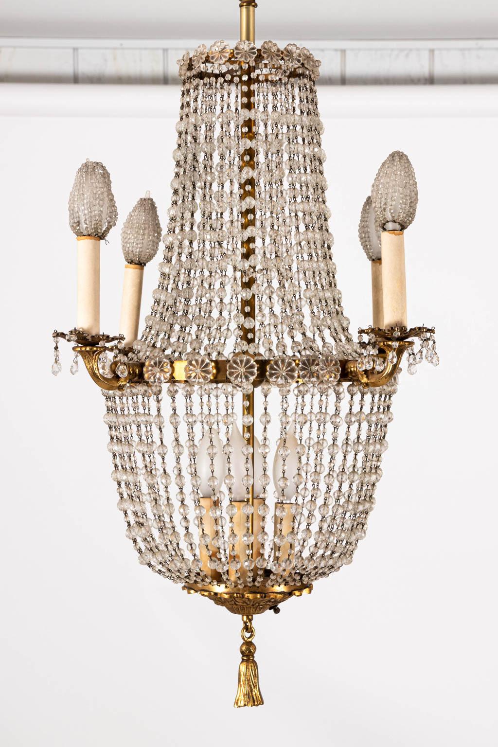 French style crystal beaded chandelier with four external arms and three internal lights inside the Brass basket frame, circa 1960s. Please note of wear consistent with age, and need to be rewired. Made in the United States. Shades not included.
