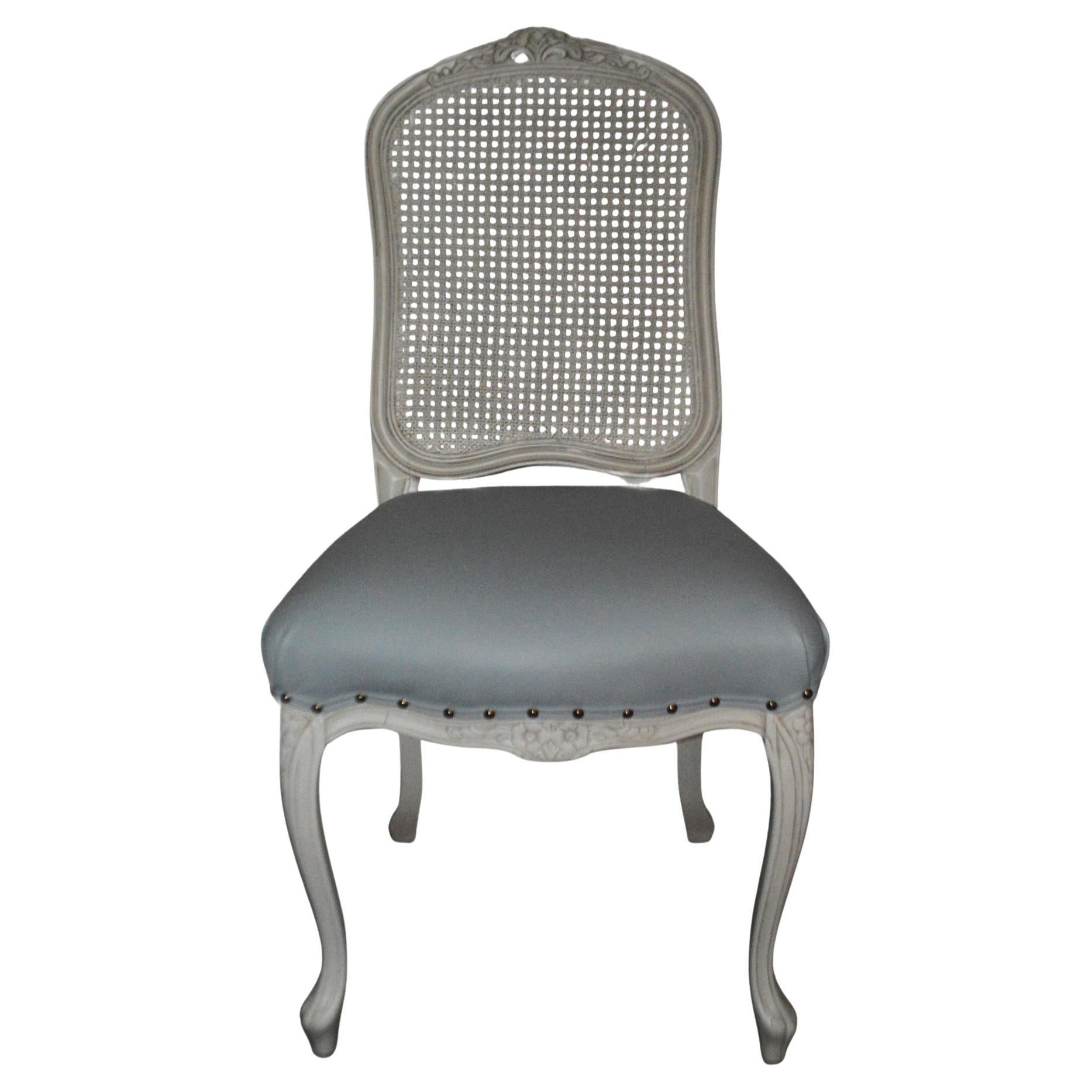 Silla de comedor de estilo francés con respaldo de caña que se ofrece en acabado personalizado.