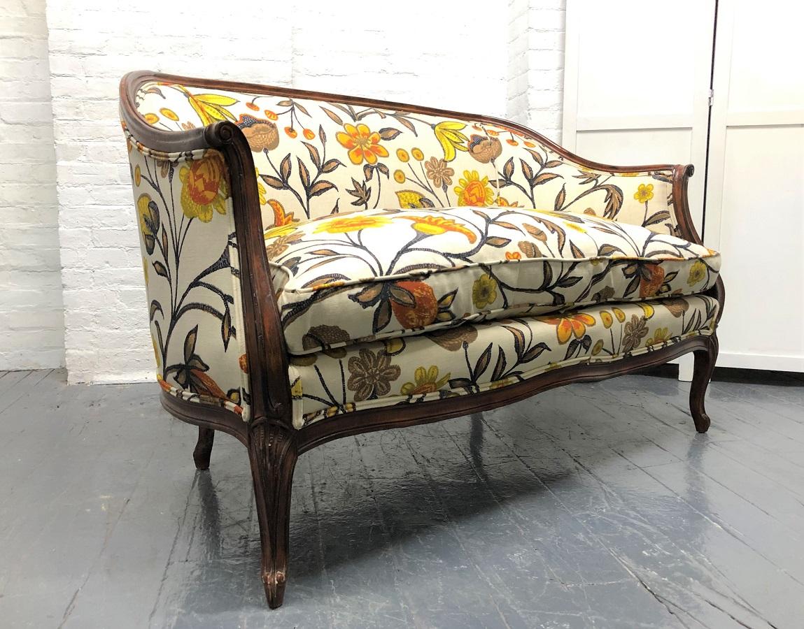 French style floral upholstered loveseat with a dark stained wooden frame. Also has a down filled cushioned seat.