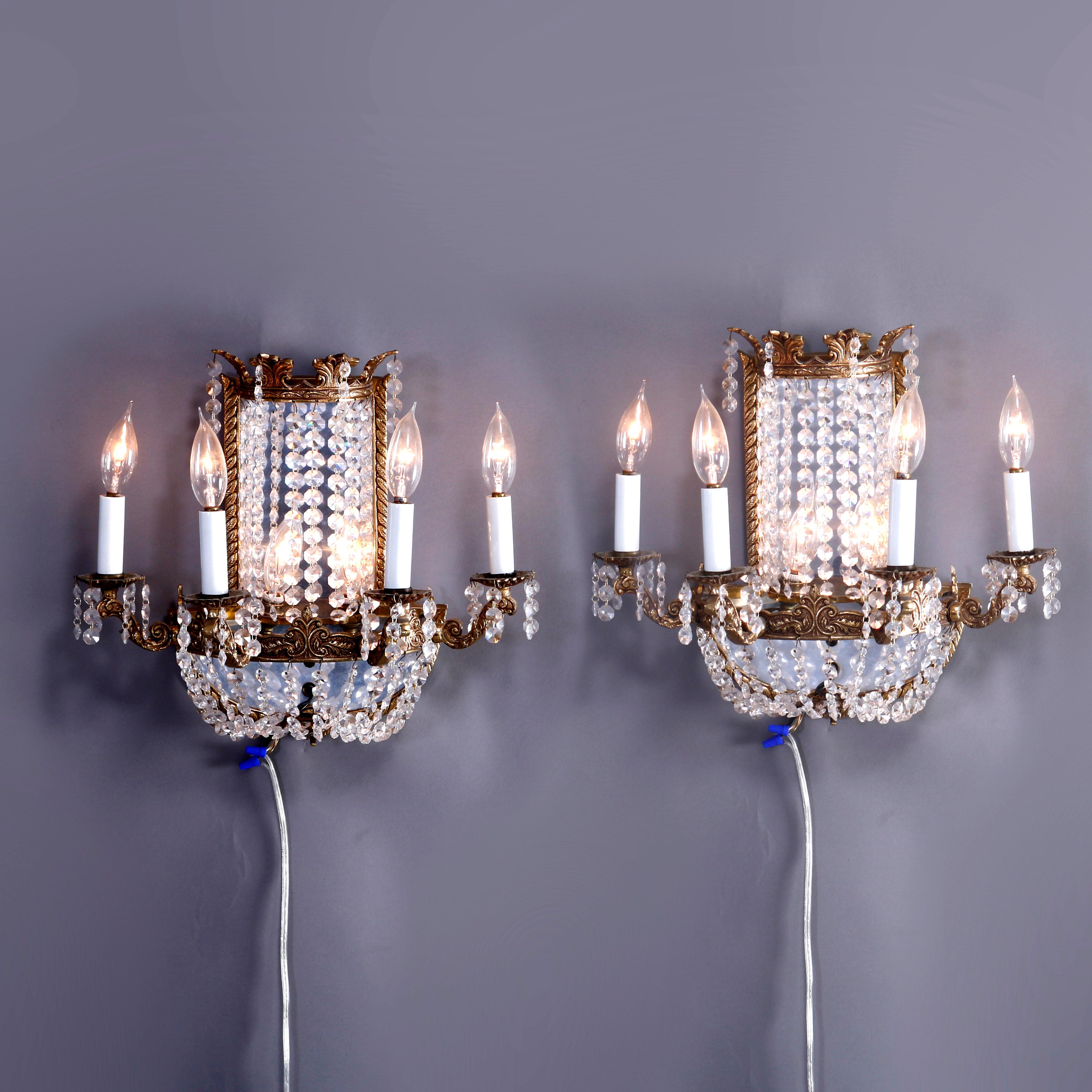 A pair of French style wall sconces offer gilt bronze frames with mirrored sconce having rope twist frame and foliate embossed demilune base with four scroll form arms terminating in candle lights and cut crystals throughout, 20th