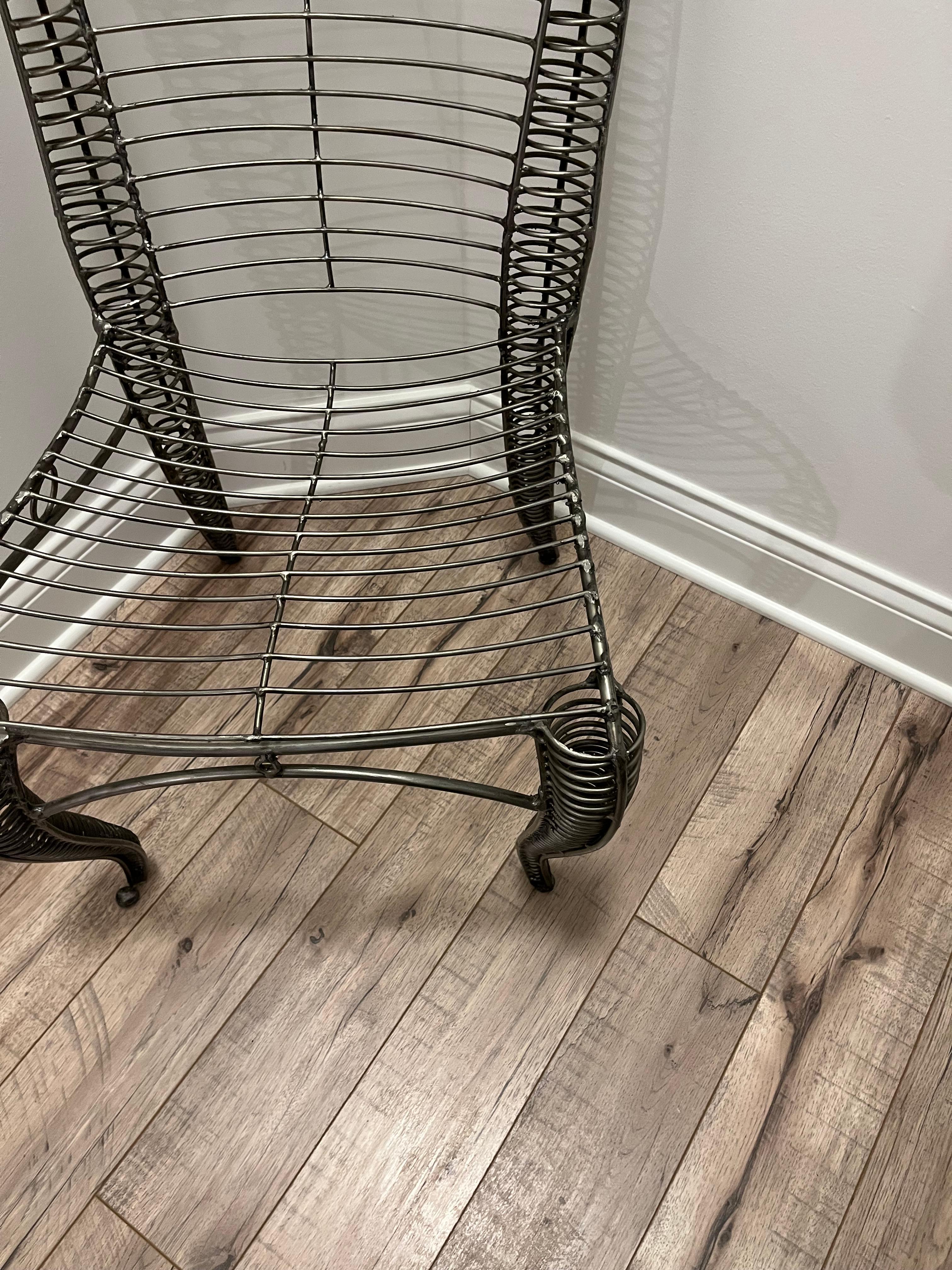 A vintage sculptural iron chair in the style of Andre  Dubreuil. Very comfortable if one chooses to sit or you may choose to admire this chair as an entryway or hallway sculpture .