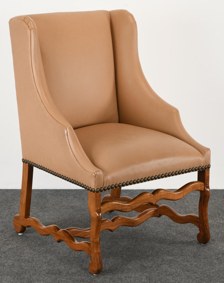 A luxurious camel leather wing chair in the Louis XIV Style by Kreiss Collection. The supple leather on this chair is in very good condition. The honey-colored fruitwood is a beautiful accent, as well as the nail head detailed seat. Structurally