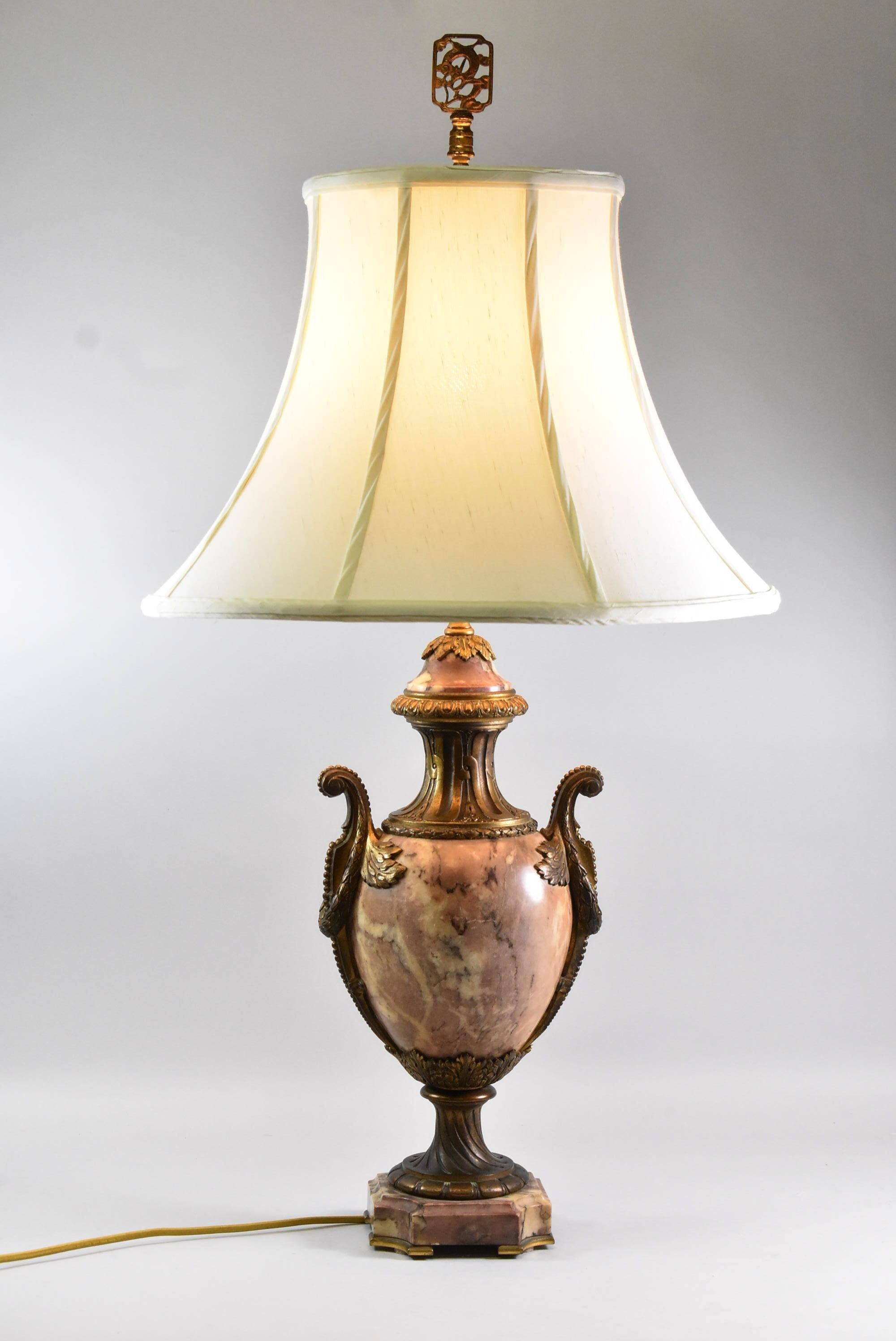 Lampe de table de style français en marbre et laiton en forme d'urne. Marbre tacheté dans les tons mauve, crème, bordeaux et gris.
L'abat-jour n'est pas inclus.