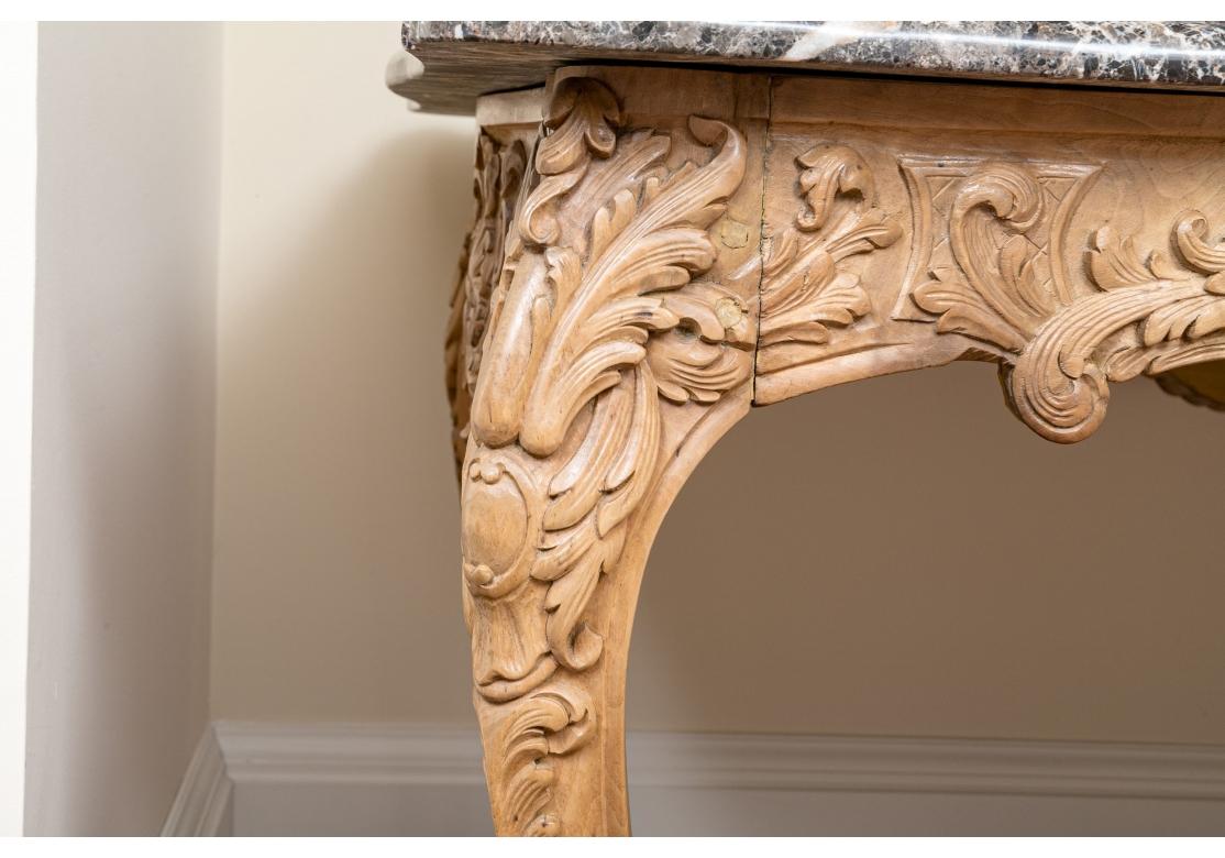 A scalloped and beveled multi-colored marble top dining table with an elaborately carved wooden base having a swag, pierced shell and waterleaf motif resting on curved scroll legs.
Dimensions: 63