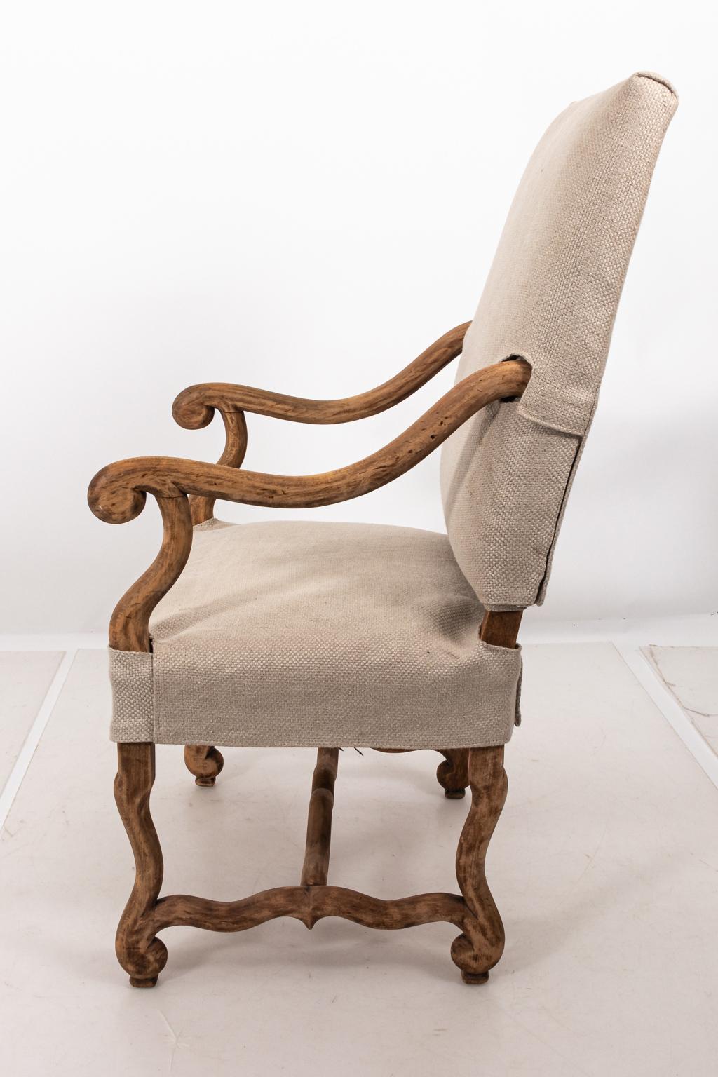 French Provencal style Os de Mouton armchair that features scrolled arms and tailored sand colored Belgian linen upholstery with slip cover, circa mid-20th century. Please note of wear consistent with age including minor evidence of finish loss on