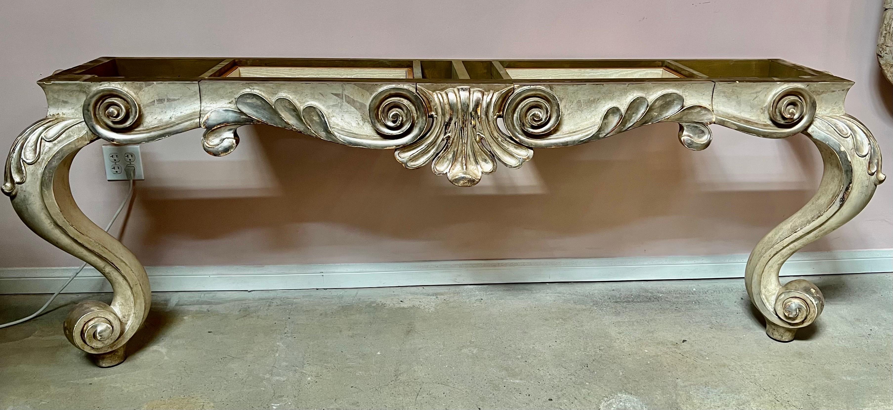 Console monumentale de style Louis XV peinte et dorée à la feuille avec plateau en marbre. La console repose sur deux pieds cabriole qui se terminent par des pieds à volutes. Le tiroir central est utilisé comme rangement. Plateau en marbre crème