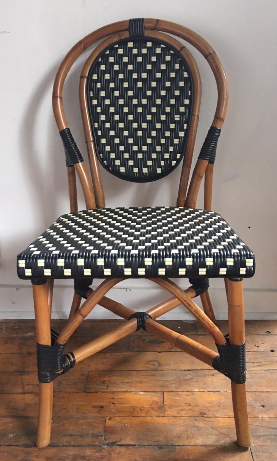 Classic French style bistro dining side chairs just like those you find in a Paris café. Frames expertly hand crafted of natural Malacca/Manau steamed bent cane with neutral black/ivory woven nylon seats and backs. For indoor and outdoor use under