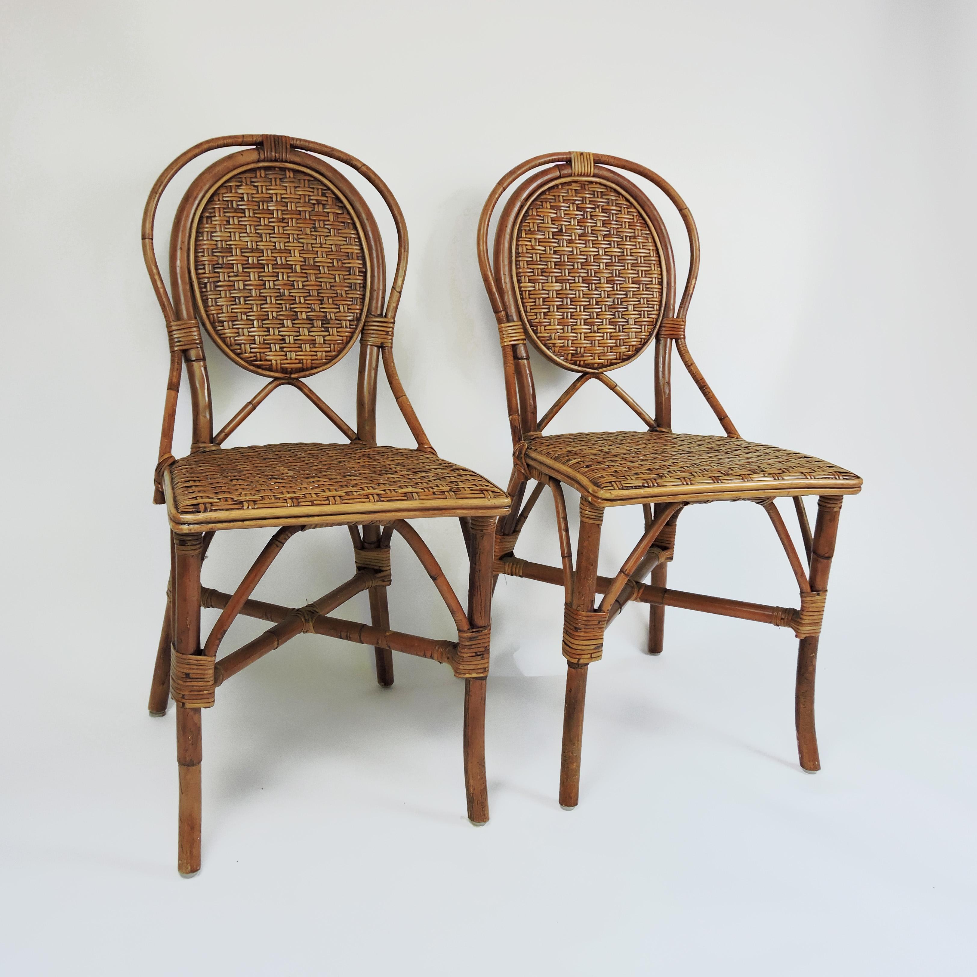 Set of 4 French style bistro dining side chairs. For indoor and outdoor use. The chairs feature a woven rattan detailing.