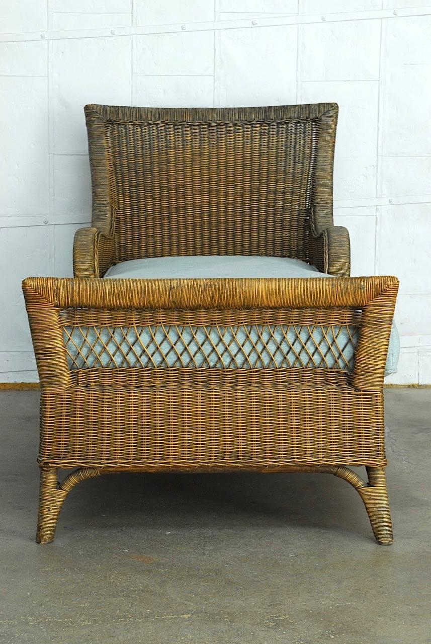 Impressive French style chaise longue, daybed, or lounge constructed from wicker and rattan. Made in the style and manner of Grange with graceful wrapped arms and a wicker wrapped frame. The seat has a snug fitted linen cushion that measures 5