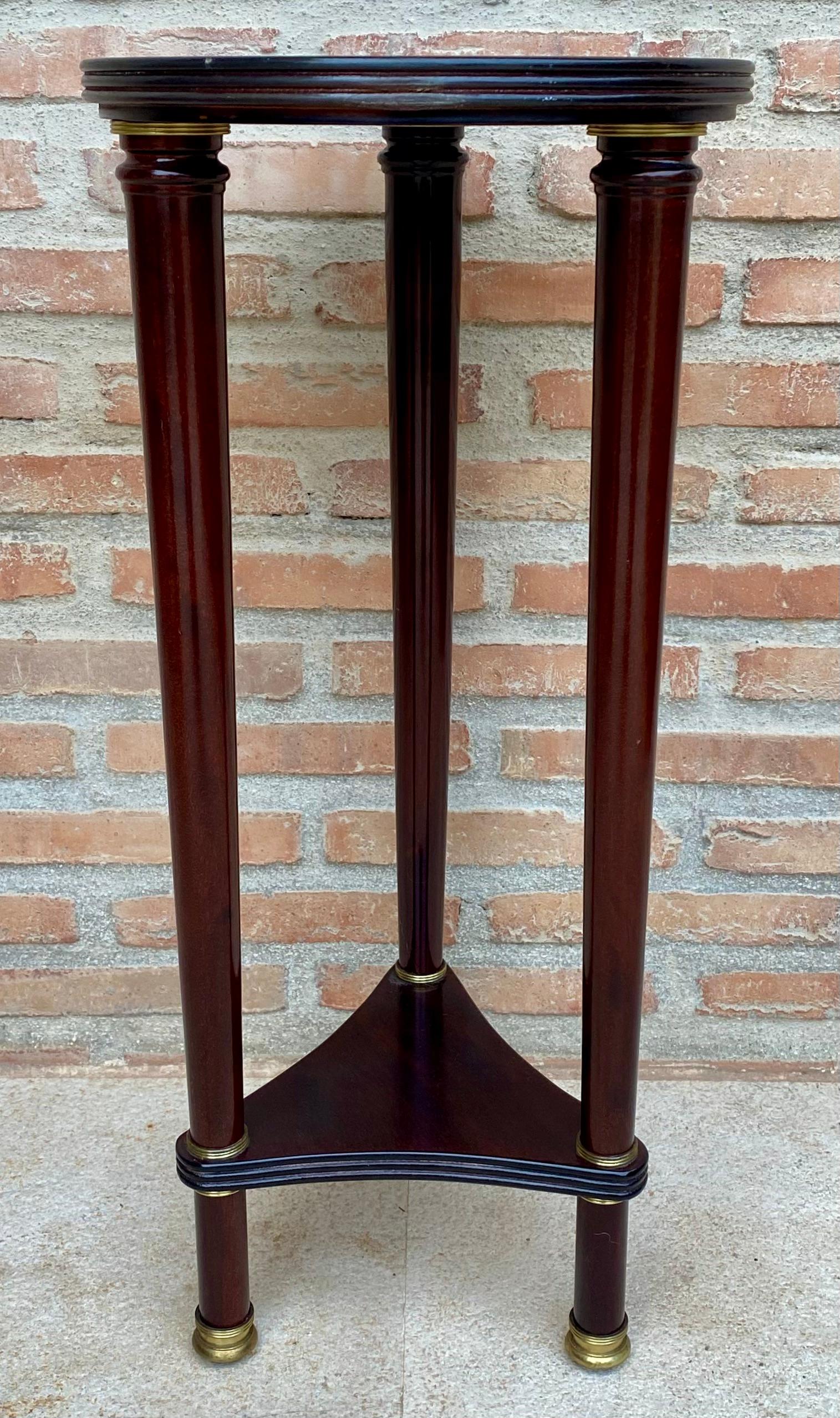 Tavolo con piedistallo in stile francese vintage. Realizzato in legno con una base triangolare che sostiene colonne tornite e un piano rotondo in legno.