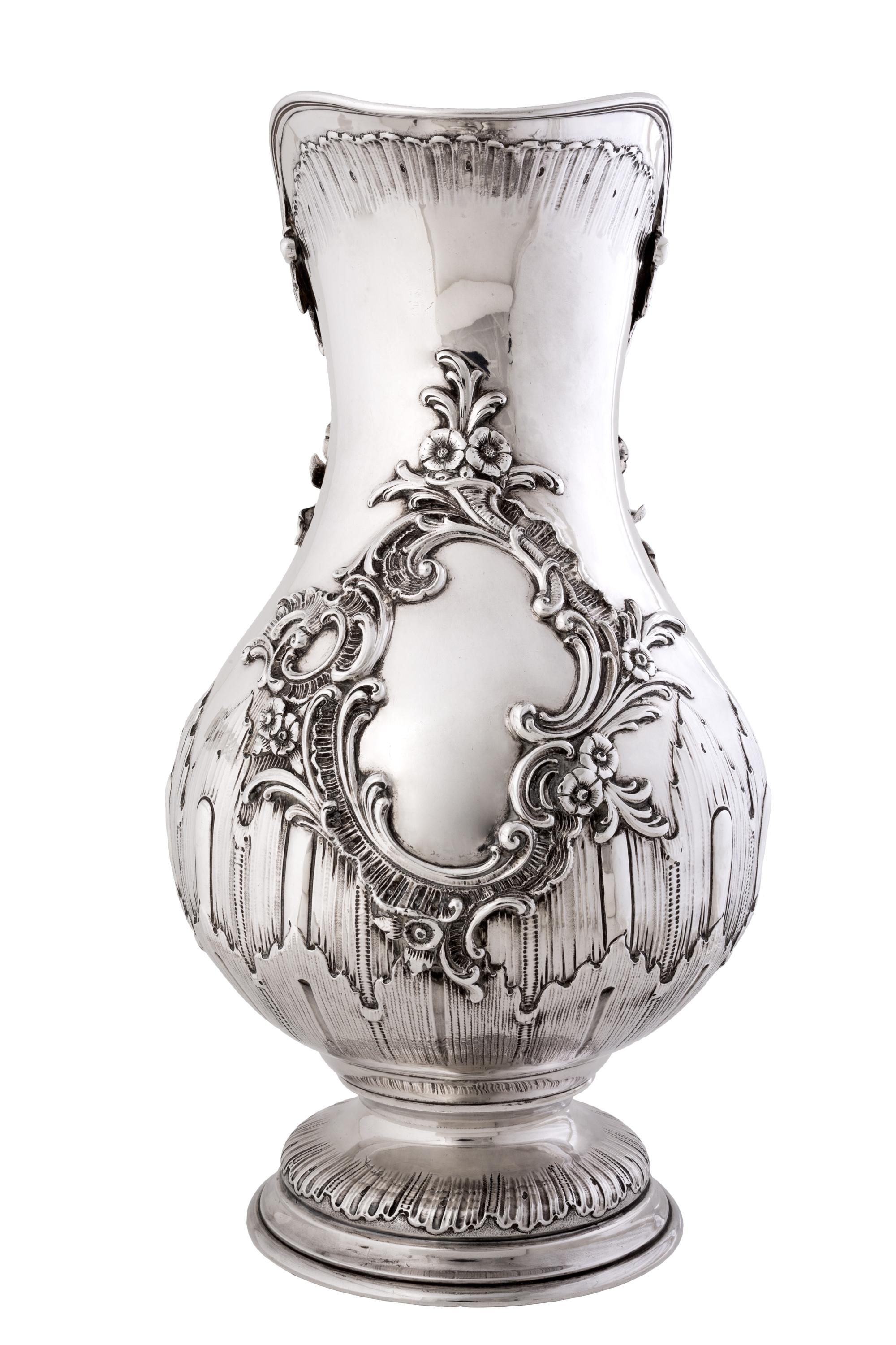 This late 19th / early 20th century large scale .950 (better than sterling) silver water pitcher features sculptural cast and applied floral decoration and abstract elements in a French style. Its large size and detailed decoration makes it a