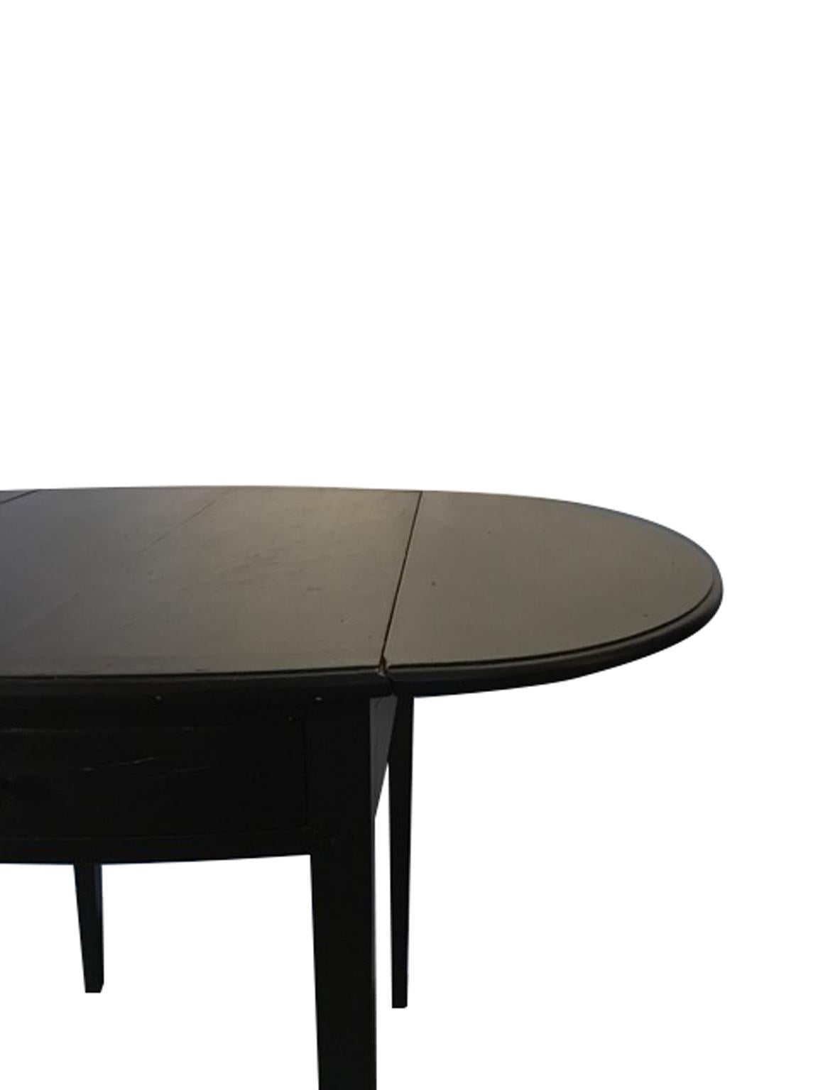 This useful and elegant table has a flap on each side which can be raised and lowered as required. 
The two drawers are fakes. The hand crafted finish reproduce the appearance of an antique piece of furniture. 

Contemporary production. Totally made