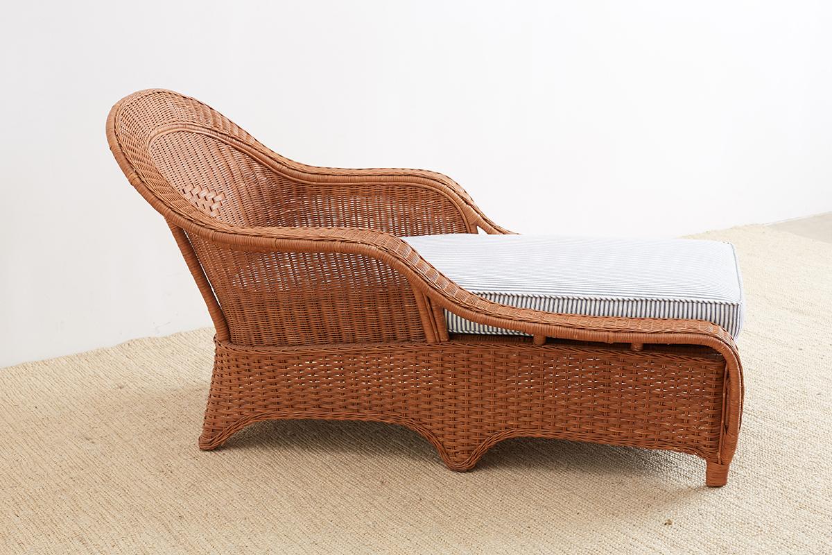French style wicker, rattan, and bamboo chaise longue or lounge produced by Palecek of San Francisco, CA. Graceful sloping arms are contrasted by the Art Deco style geometric accented seat. The bamboo frame is covered by beautiful sheets of woven