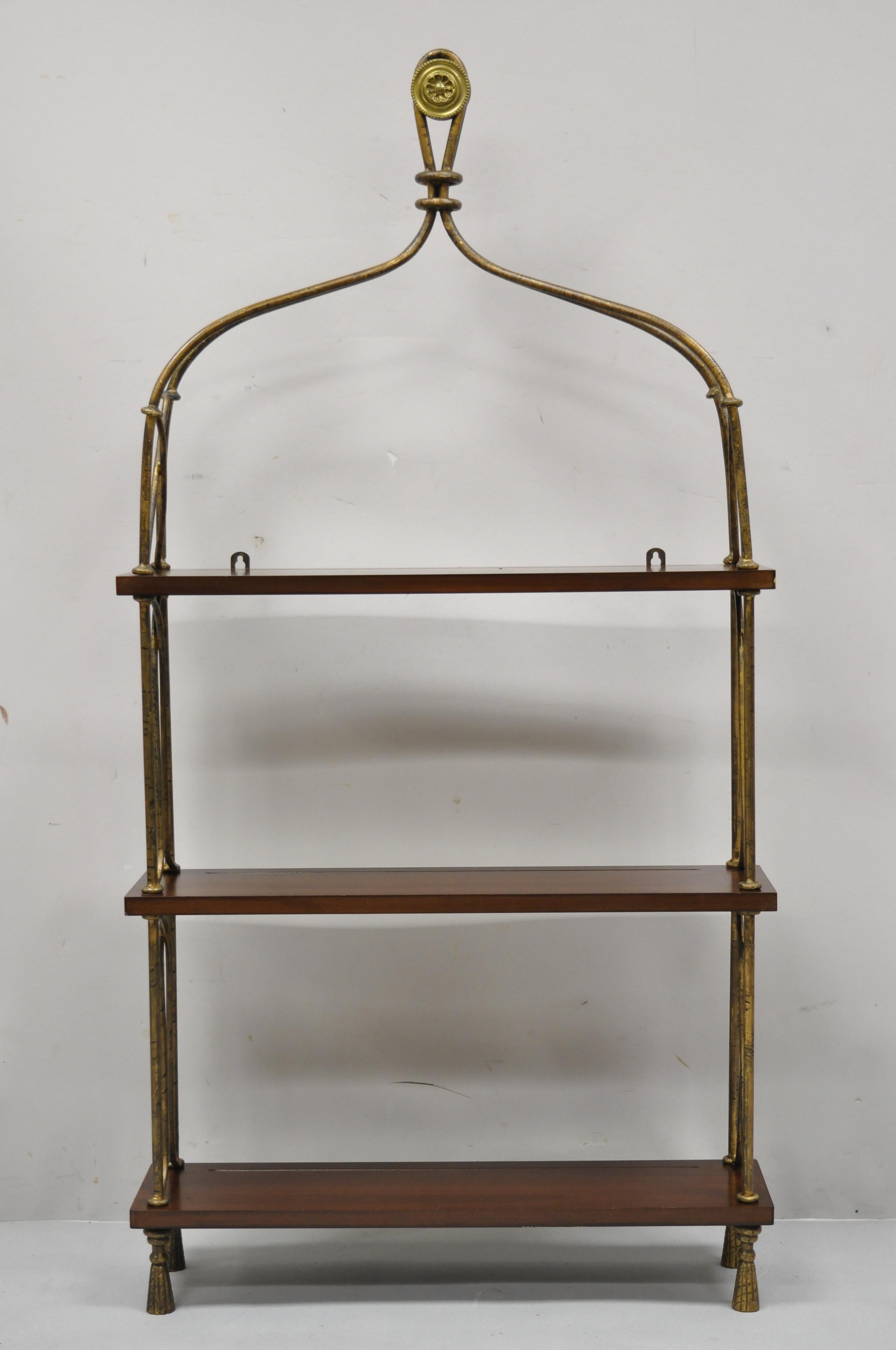 French style wrought iron and wooden shelf wall mount shelf curio display cabinet by Global Views. Item features iron tassel feet, iron frame, distressed gold finish, 3 solid wood shelves with plate grooves, brass medallion finial, original label,