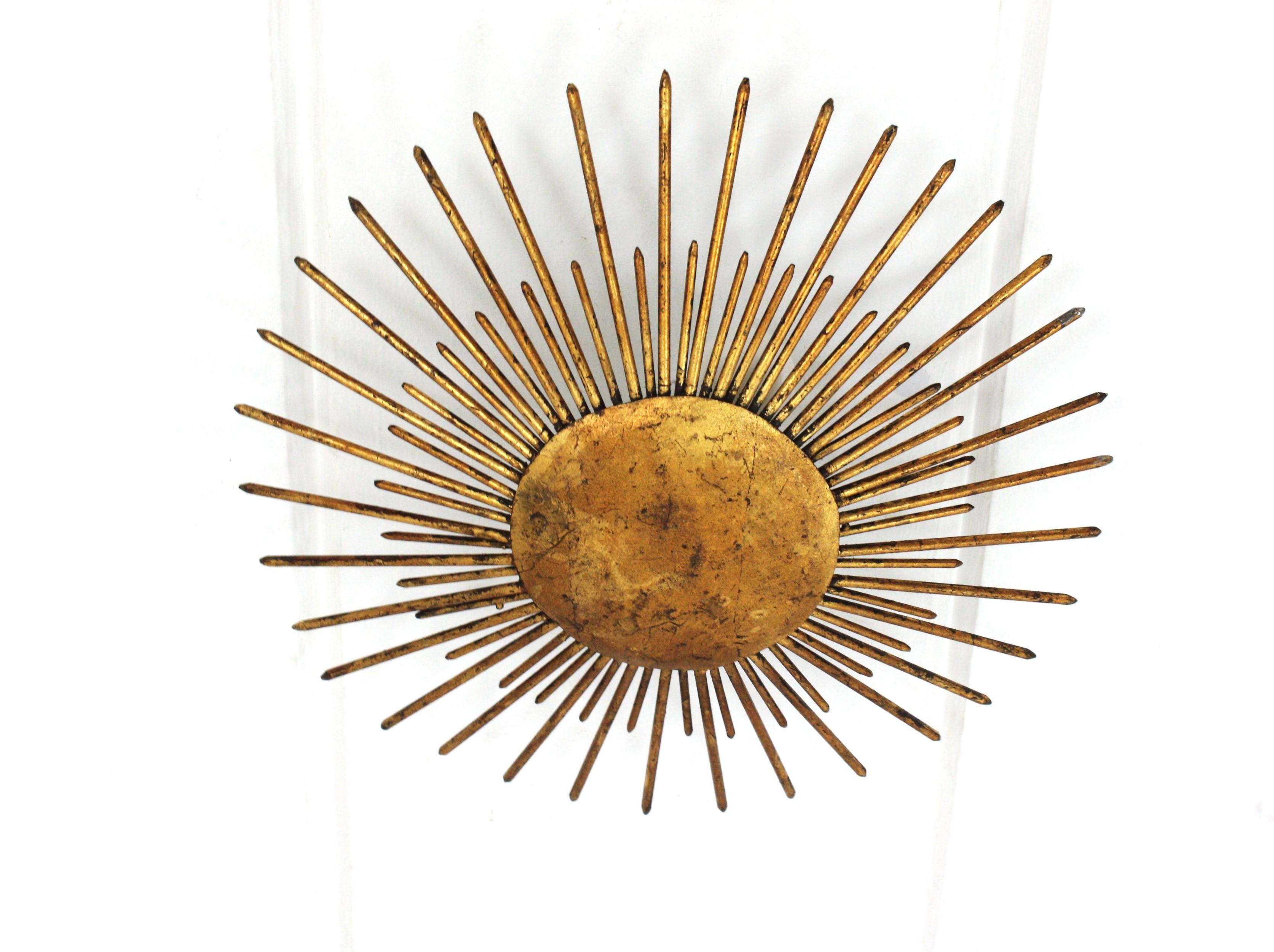 French Modern Neoclassical Sunburst Light Fixture with Spikes Detail,  France, 1940s
This stunning hand-hammered gilt iron sunburst ceiling light was manufactured at the Art Deco Period. It has accents in transition to Brutalist style. 
A sunburst