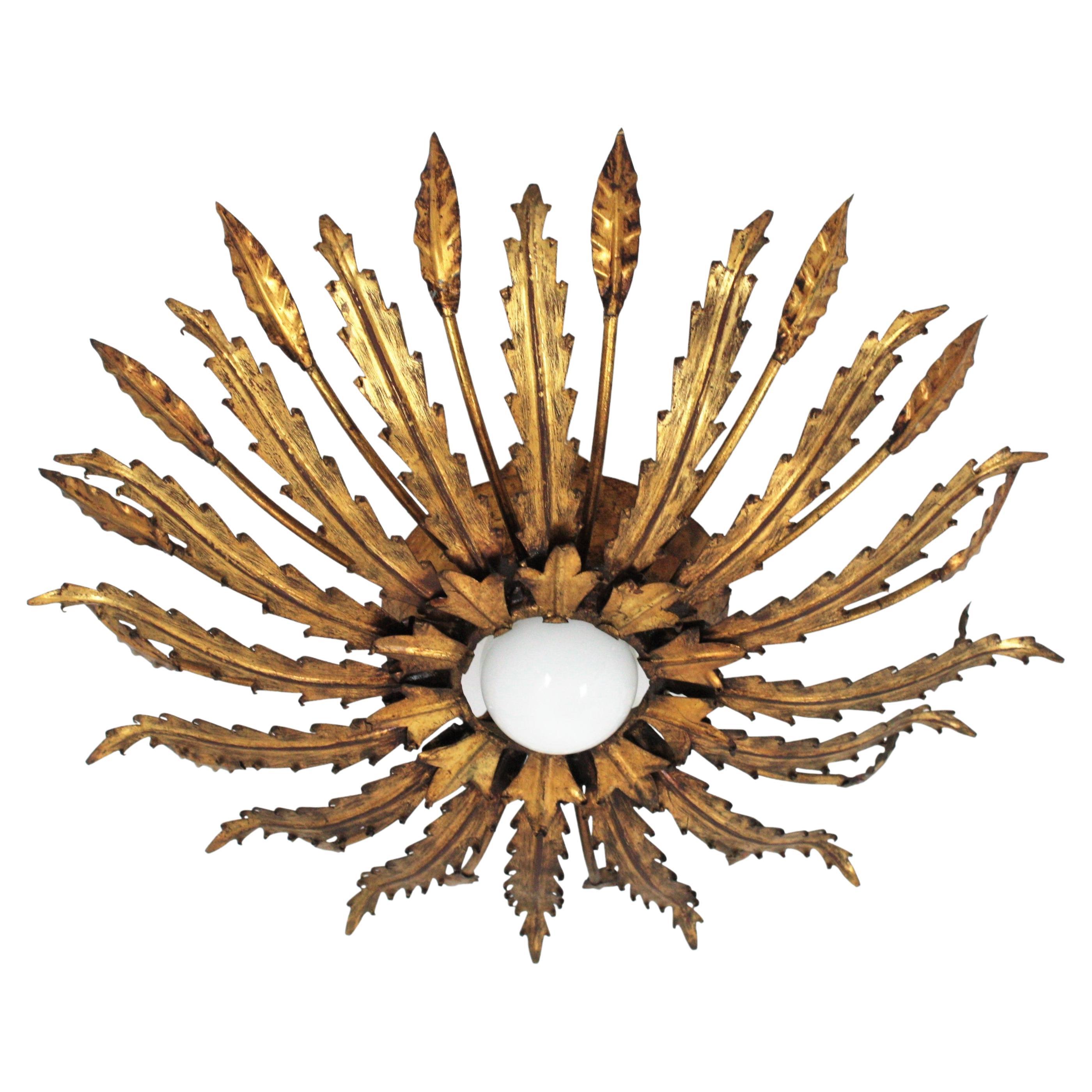 Sunburst ceiling light fixture, iron, gold leaf.
A beautiful Brutalist hand-hammered gilt iron sunburst flush mount with leafed design, France, 1950s.
Entirely made by hand.
Original Gold leaf gilding and fabulous patina.
This eye-catching