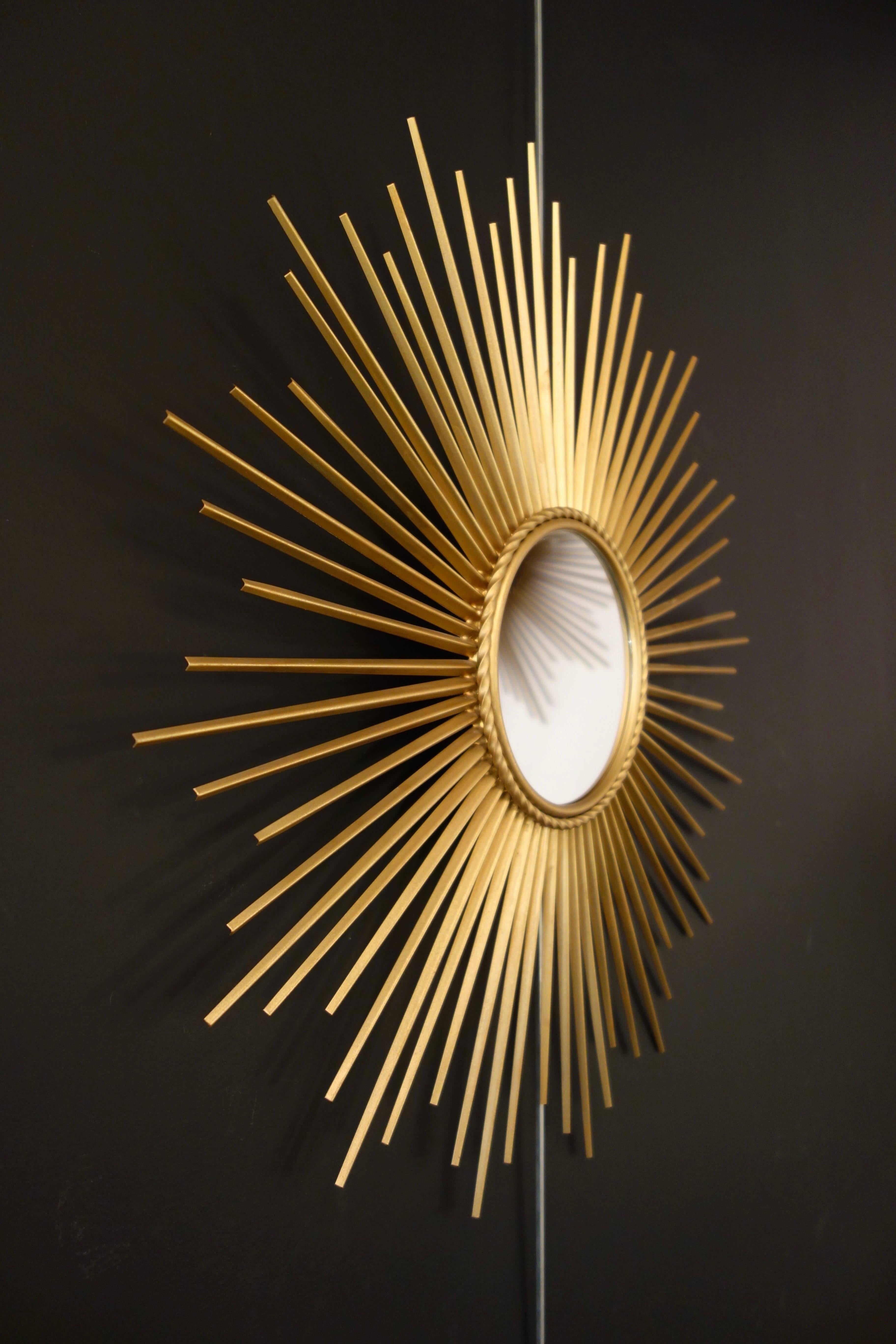 Sunburst mirror by Chaty Vallauris. French manufacture of the 1960s. No Signed, the cardboard was replaced at one time. Golden metal rods and traditional mirror. In perfect condition: no twisted or damaged stems, beautiful patina. Wall hook. Total