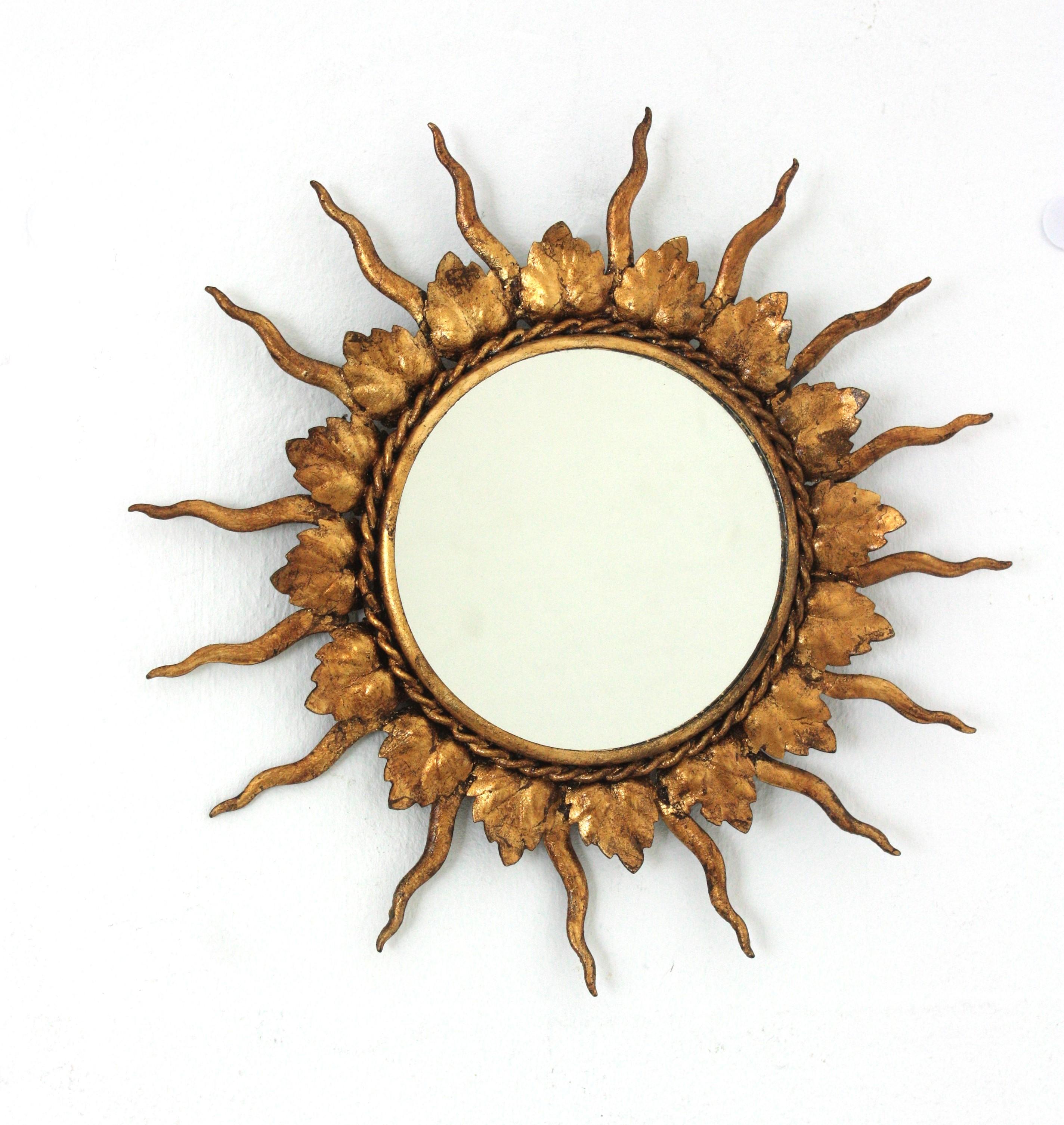 Mini sized sunburst mirror in gilt iron. France, 1950s
Lovely handcrafted gilt iron mini sunburst mirror. The frame is comprised by alternating iron leaves and rays finished with gold leaf gilding.
Unusual piece due to its small size.
Beautiful
