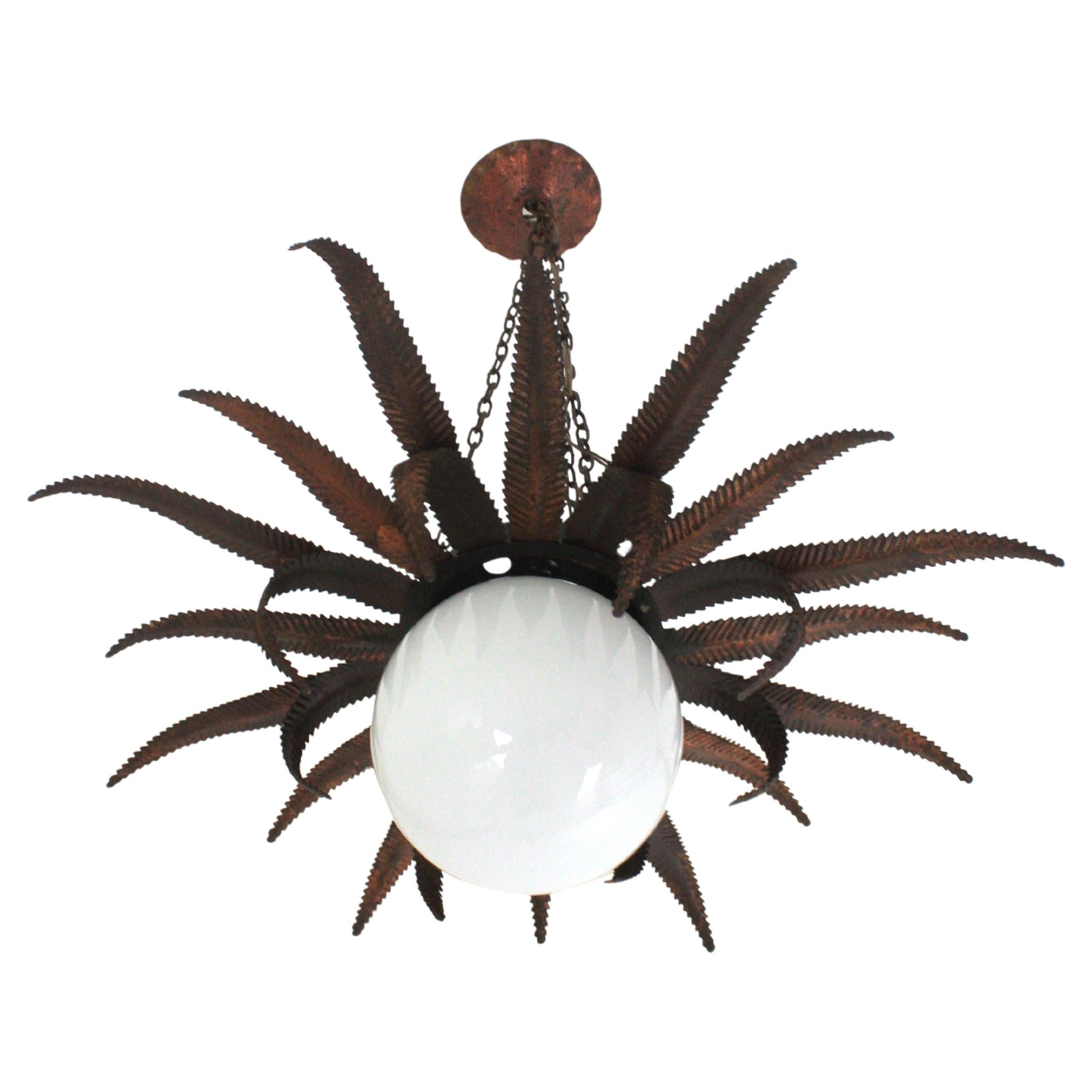 Sunburst Leafed Pendant Ceiling Light with Milk Glass Globe
Outstanding French sunburst pendant in coppered metal and milk glass, 1950s
This Sunburst starburst ceiling light fixture has an eye-catching construction. The sunburst backplace in