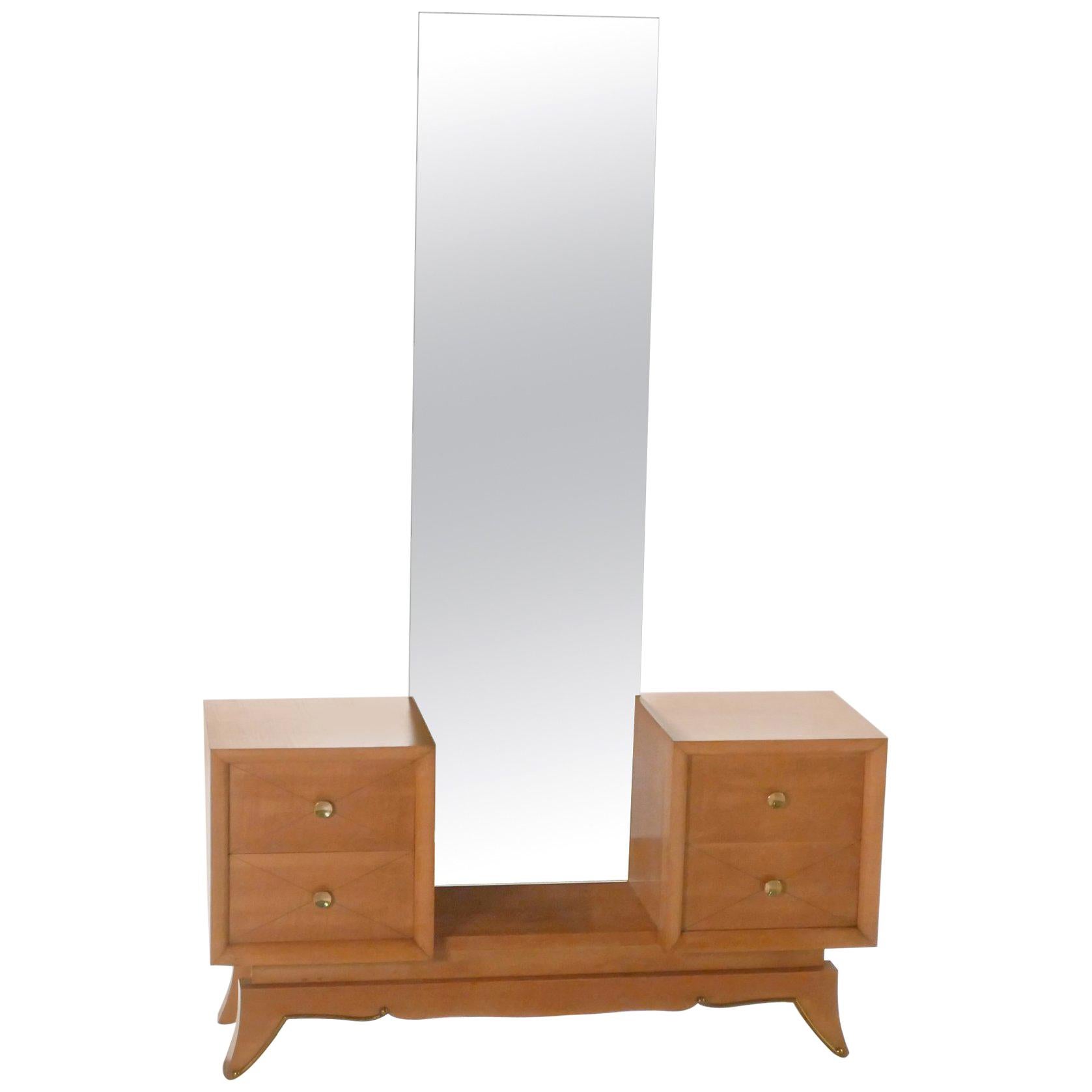 Warm sycamore maple, adorned with quality brass accents, is responsible for the cosy, romantic feeling that this piece effuses. The dressing table, with a strikingly tall mirror jutting up from its centre, is emblematic of renowned Art Deco designer