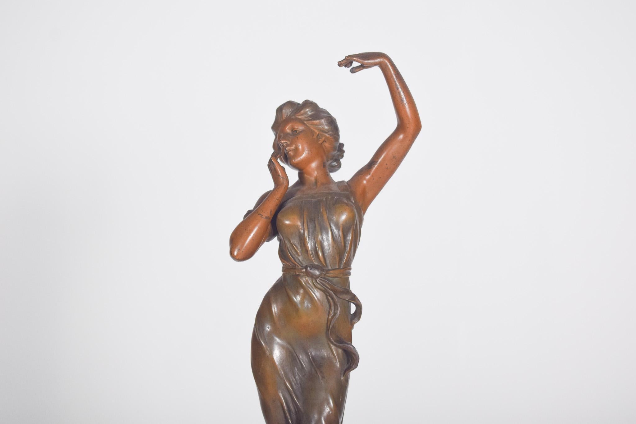 French table clock with marble base and figure.
French table clock, with a greenish marble base, topped by a lady's figure. The marble base is supported by four bronze feet decorated with flowers.
The clock face is made of white porcelain decorated