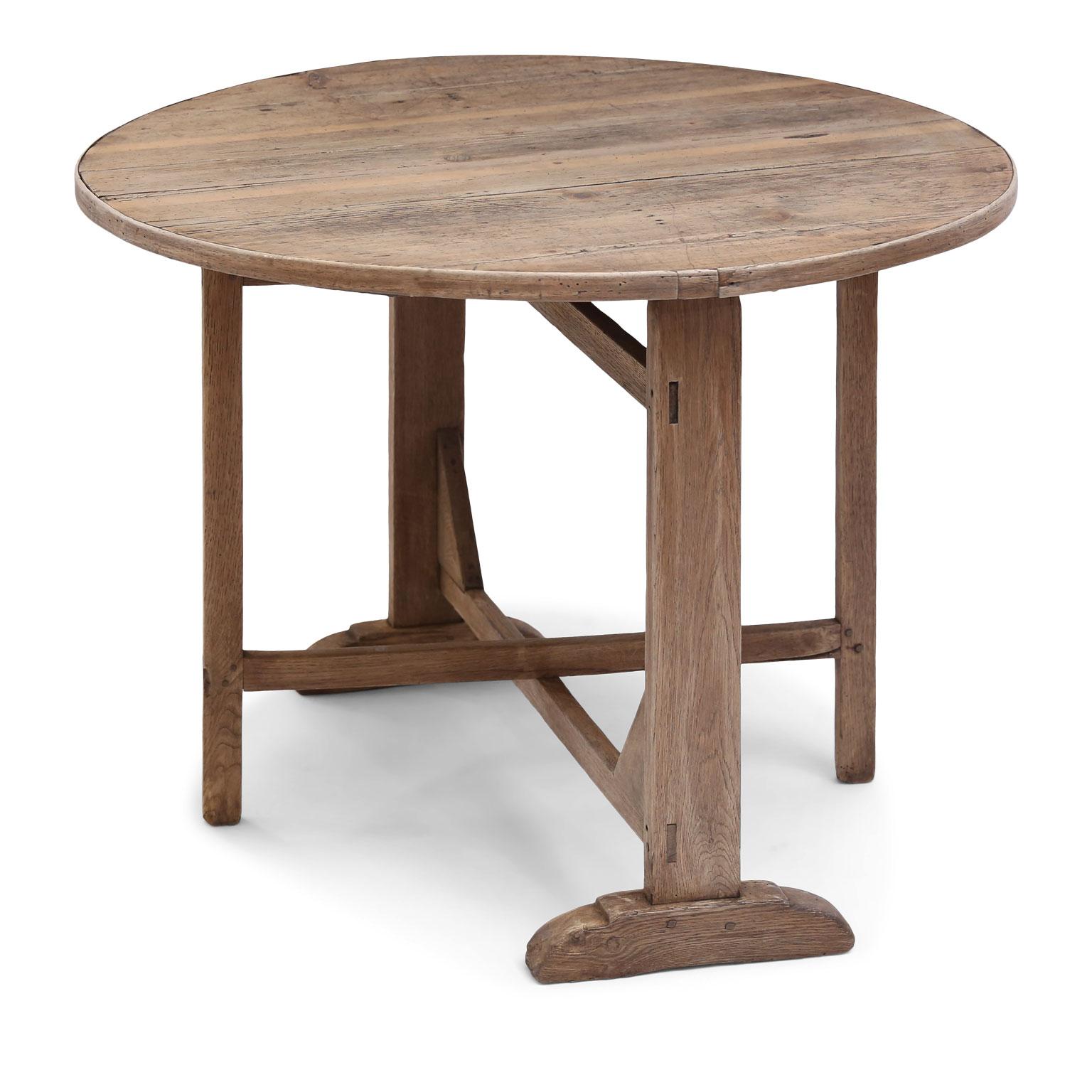 French semi-bleached brown table de vendange (wine tasting table) in oak and pine dating to the late 19th century. Stabile, sturdy mortise and Tenon construction. Pine top surrounded by bentwood edge upon a hand carved oak base. Tilt-top fully