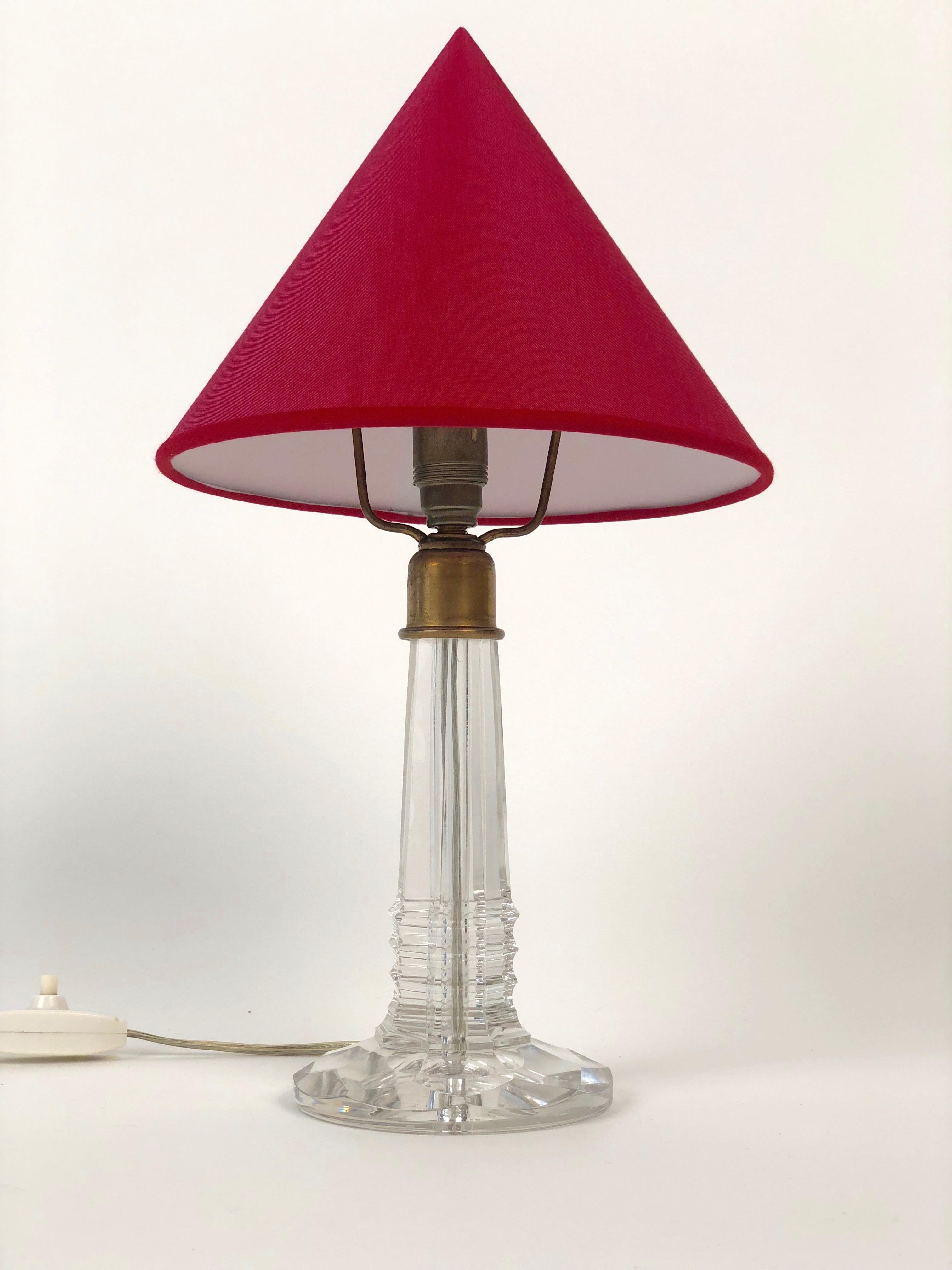 Charming small table lamp with a base formed through cut glass and brass montage elements.
A cone shape shade in red silk, is based on the original form.