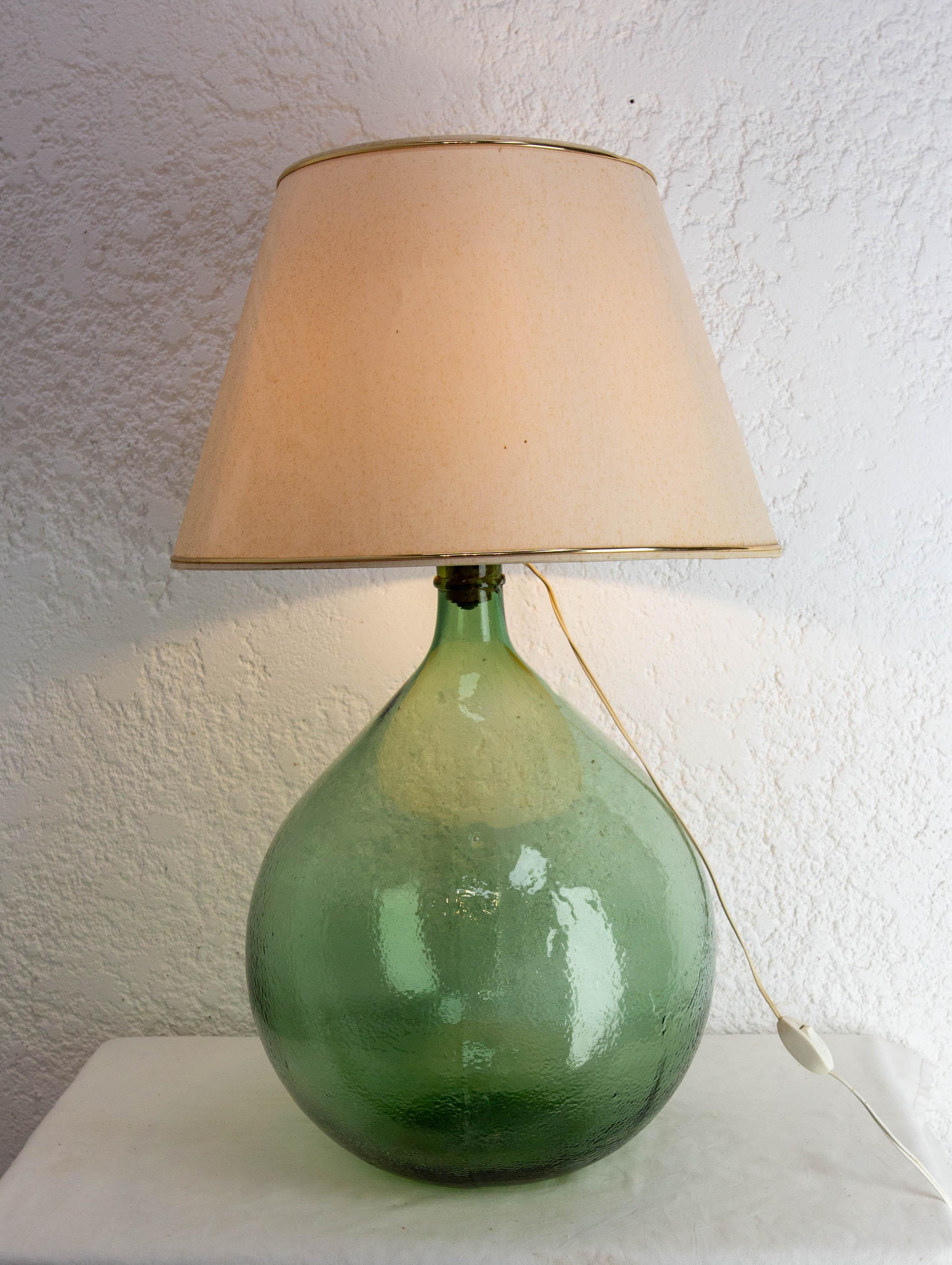 Grüne Tischlampe montiert auf einer dame Jeanne oder carboy vintage Glasflasche demijohn
Die Lampe wurde um 1960 auf die Lady Jane montiert.
Unregelmäßigkeiten im Glas, die ihm seinen ganzen Charme verleihen. Diese Karaffe ist besonders