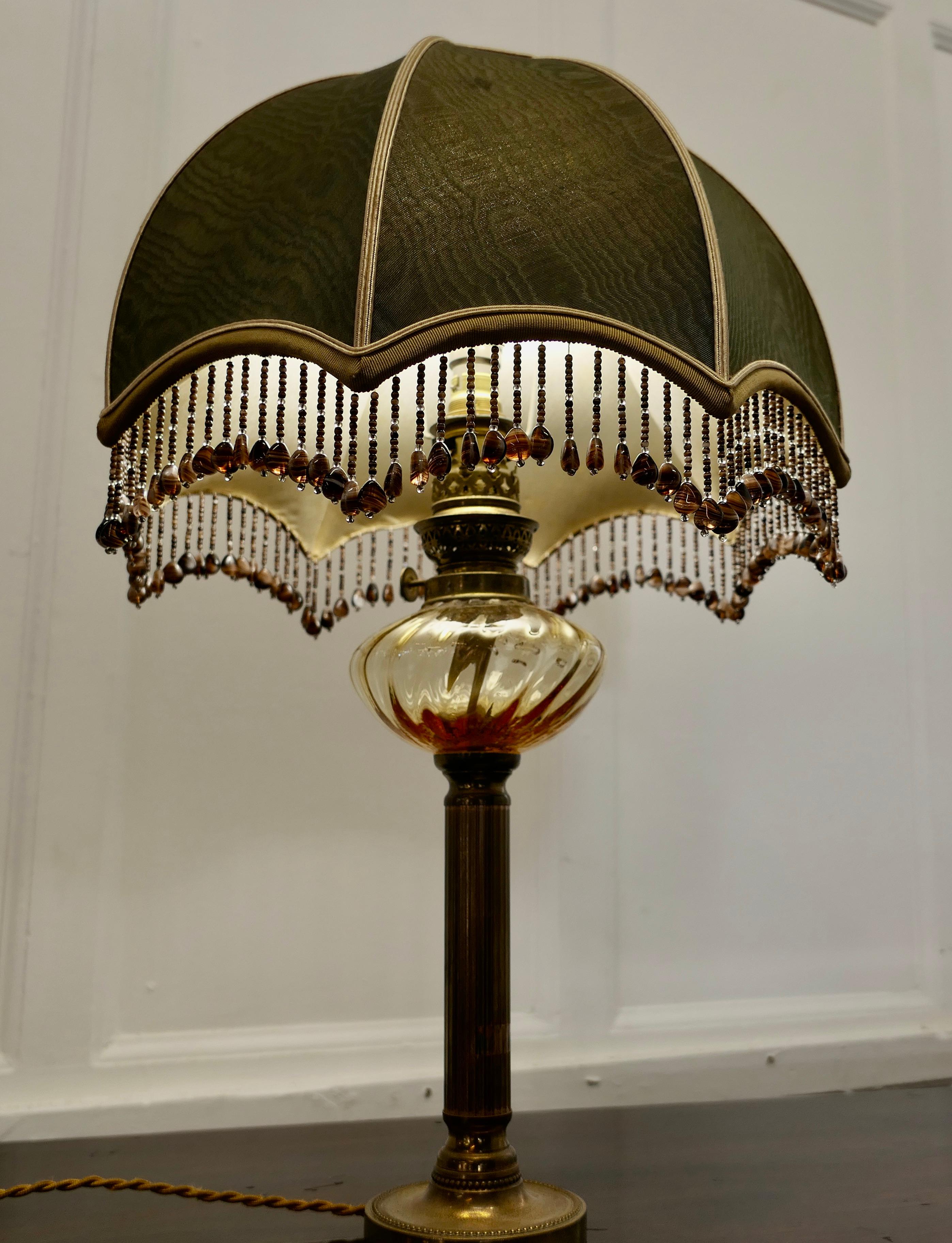 French table lamp with beaded dome lampshade

The lamp has been converted from a pretty Amber Glass and Brass Oil Lamp it is topped of with a superb Dark Green Beaded Dome lampshade 
The lamp and shade are in good used condition, the wiring is