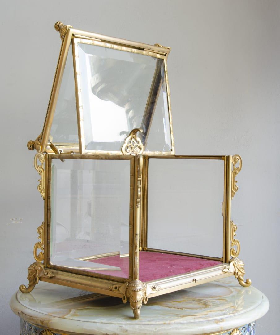 French tabletop display
in gilt bronze and beveled glass with details of chinois
with small chips in the corners of the 3 crystals.