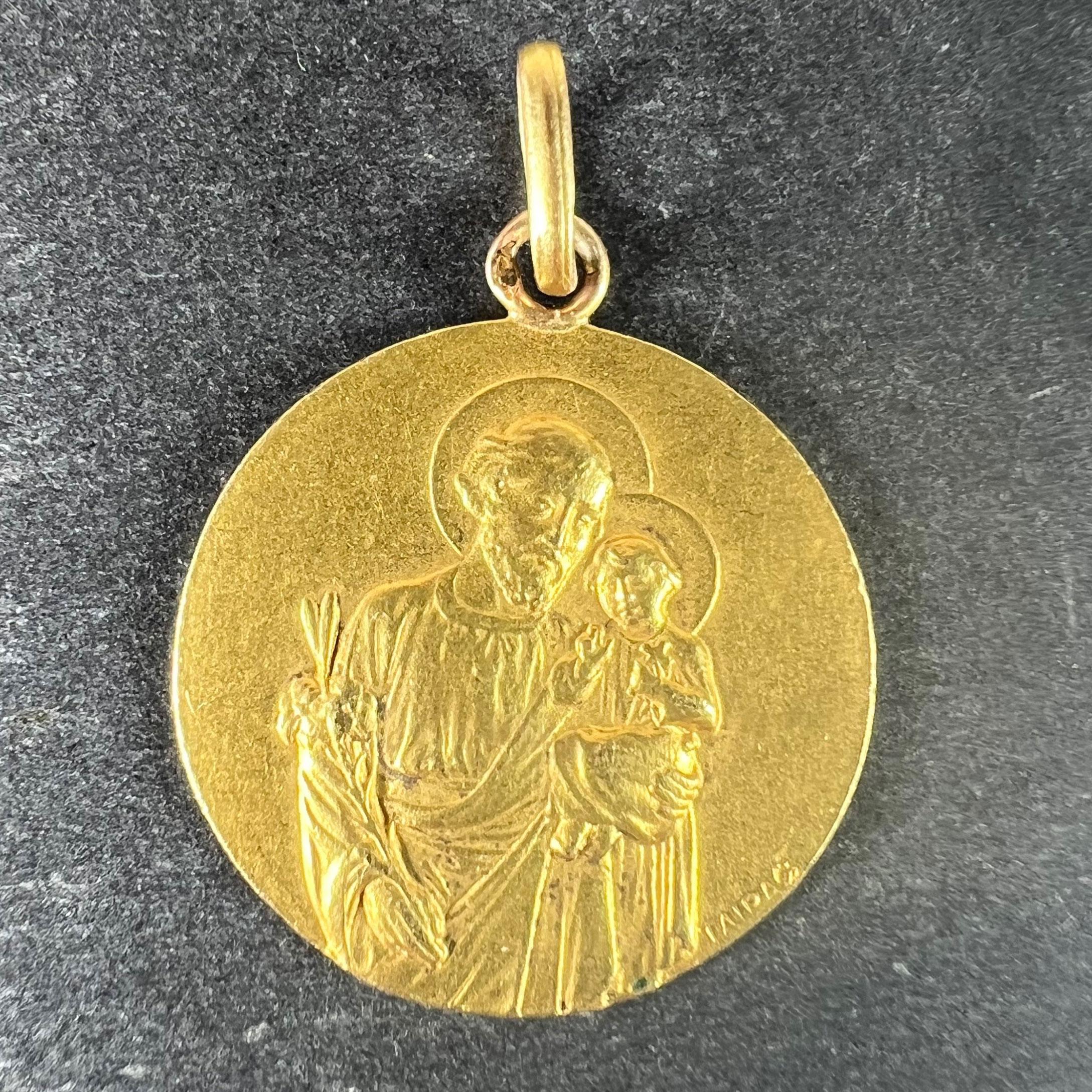 Ein französischer Anhänger aus 18 Karat (18K) Gelbgold in Form einer runden Medaille, die den heiligen Joseph mit dem Jesuskind darstellt, das ein Lilienbündel hält. Auf der Einfassung steht 