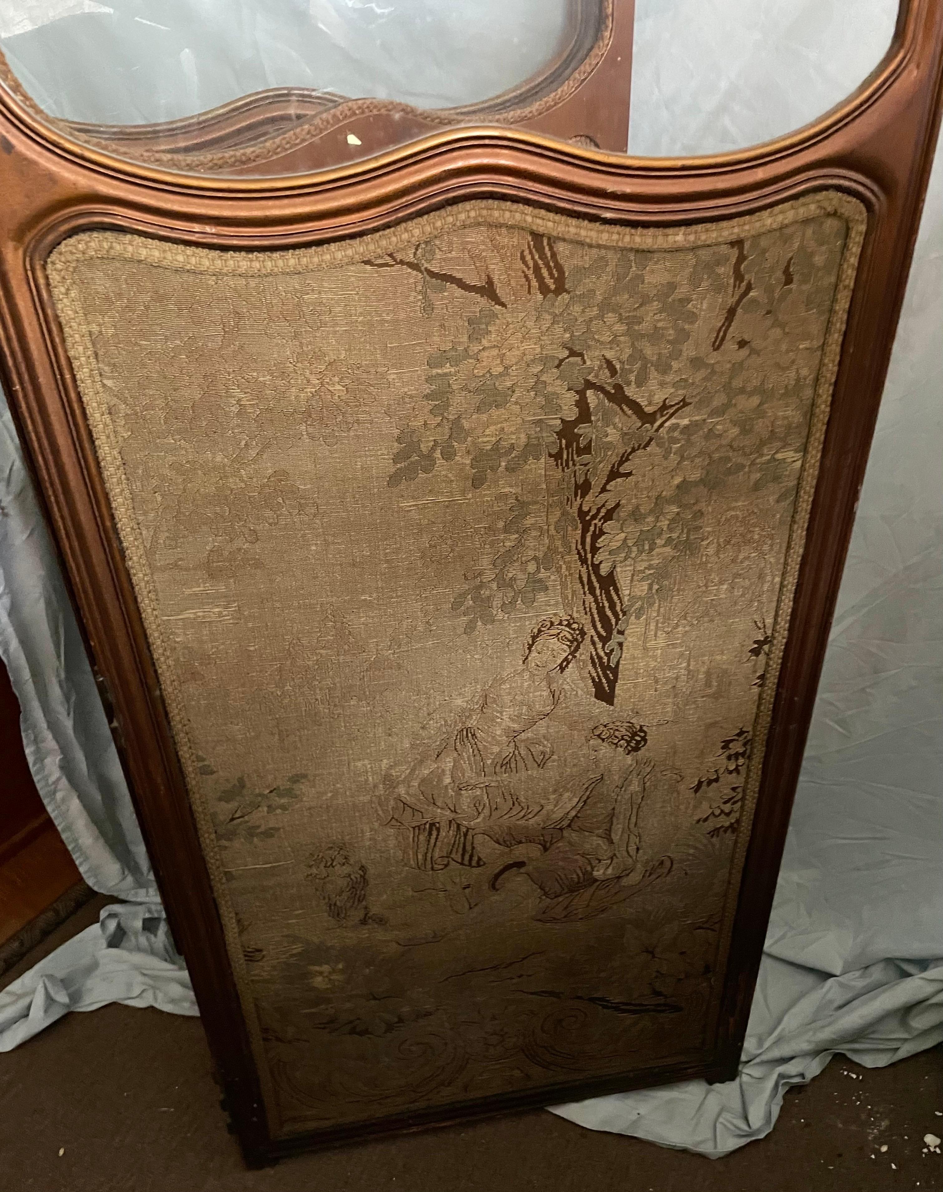 This is a lovely three panel French provincial style screen with a carved crest and a shaped glass 