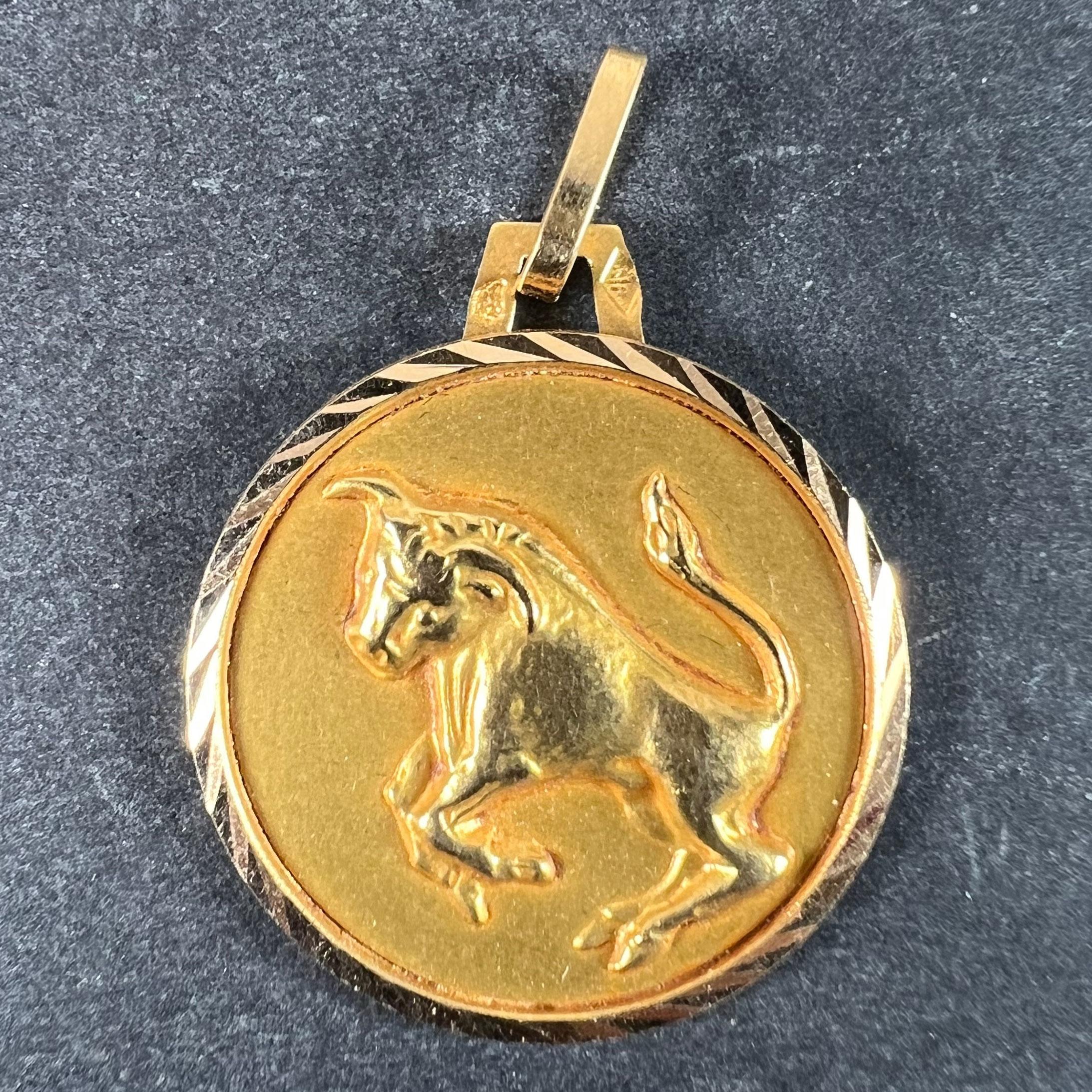 Un ciondolo francese in oro giallo 18 carati (18K) disegnato come una medaglia rotonda raffigurante un toro che si alza, che rappresenta il segno zodiacale del Taurus all'interno di una cornice rigata. Timbro a testa d'aquila per la manifattura