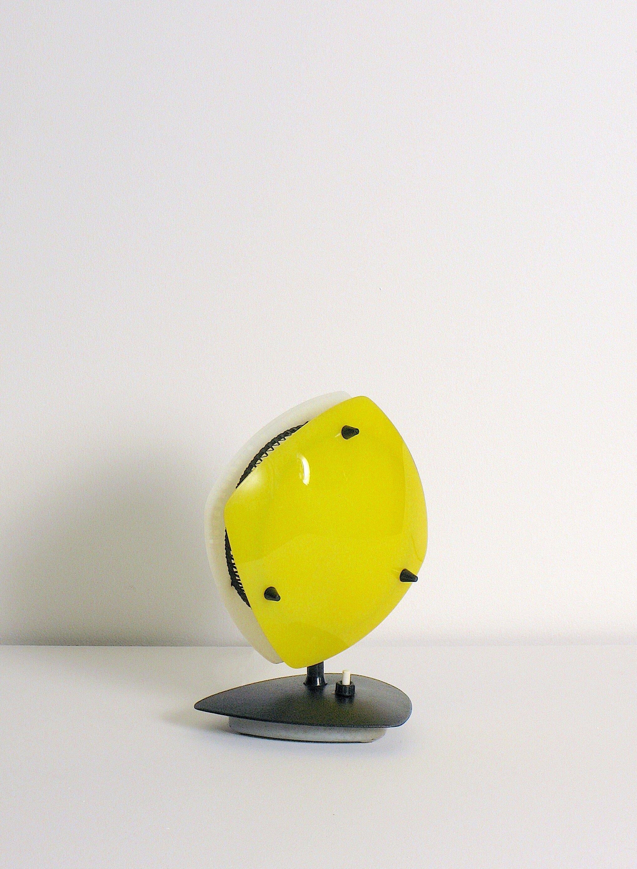 Lámpara de plexiglás de dos caras fabricada en Italia y atribuida a Arredoluce. Tulipas de panel de plexiglás moldeado amarillo y blanco sujetas por pasadores de latón esmaltado. Malla de acero esmaltado negro, base de acero esmaltado negro. Se