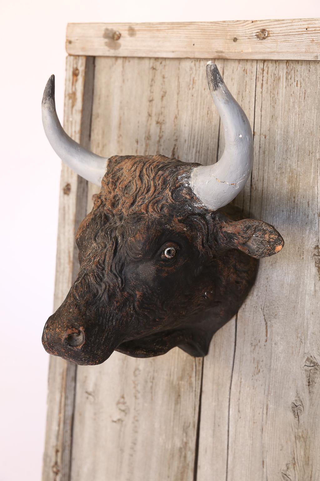 Presented as found, this antique French terracotta bull head was once used as a trade sign for a butcher shop in France. The bull head is attached to the wood by a single screw and is removable allowing it to be hung directly on the wall. The