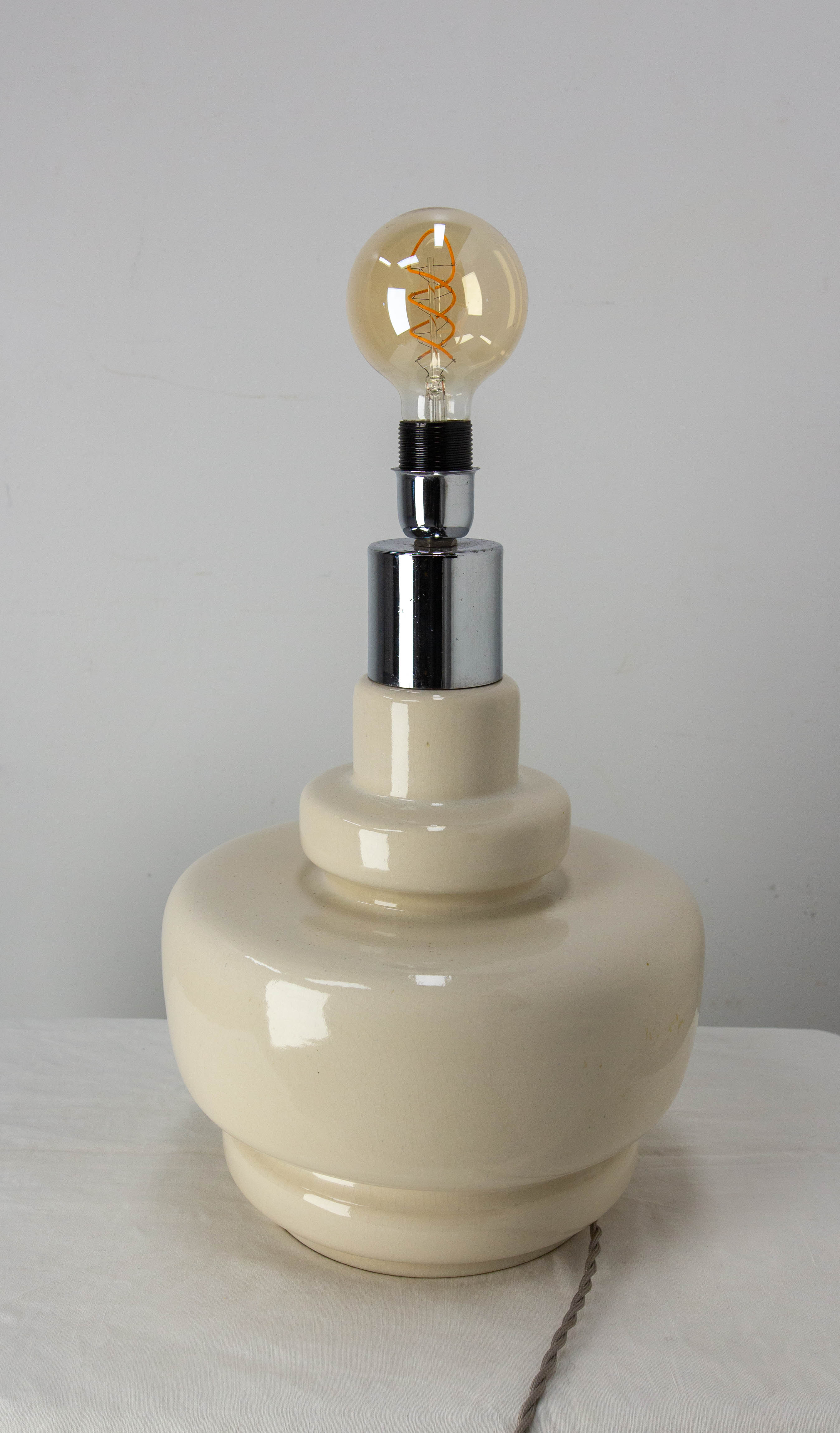 Lampe de table vintage montée sur une base en terre cuite, 
Le support de la lumière est en chrome. Les lignes épurées de cet article sont typiques des années 70 et sont encore très populaires aujourd'hui.
Hauteur donnée sans l'ampoule.
Quelques