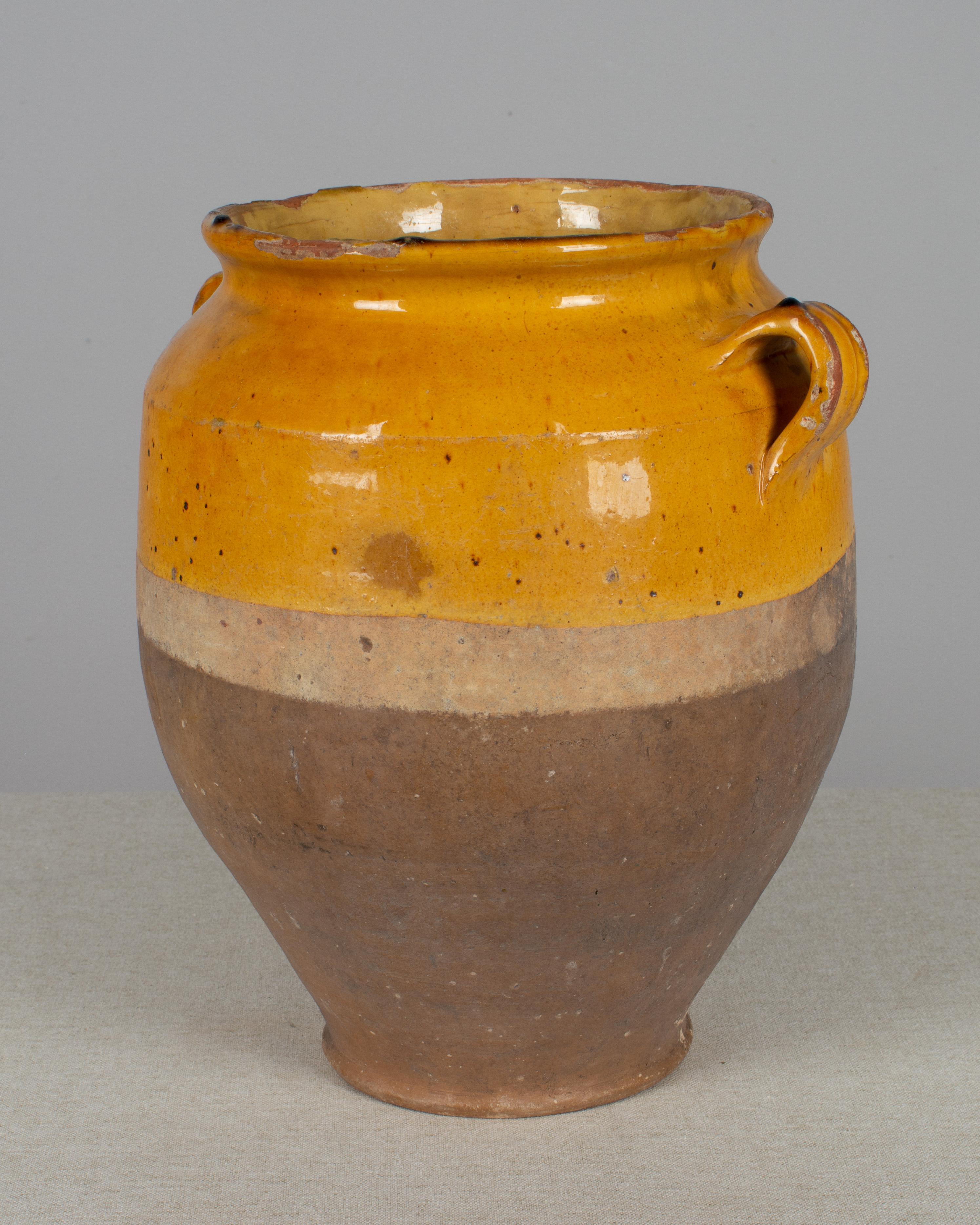 An earthenware confit pot from the Southwest of France with traditional ochre yellow glaze. Beautiful patina and bright color with a drip of green glaze. Minor losses. These ordinary earthenware vessels were once used daily in the French country