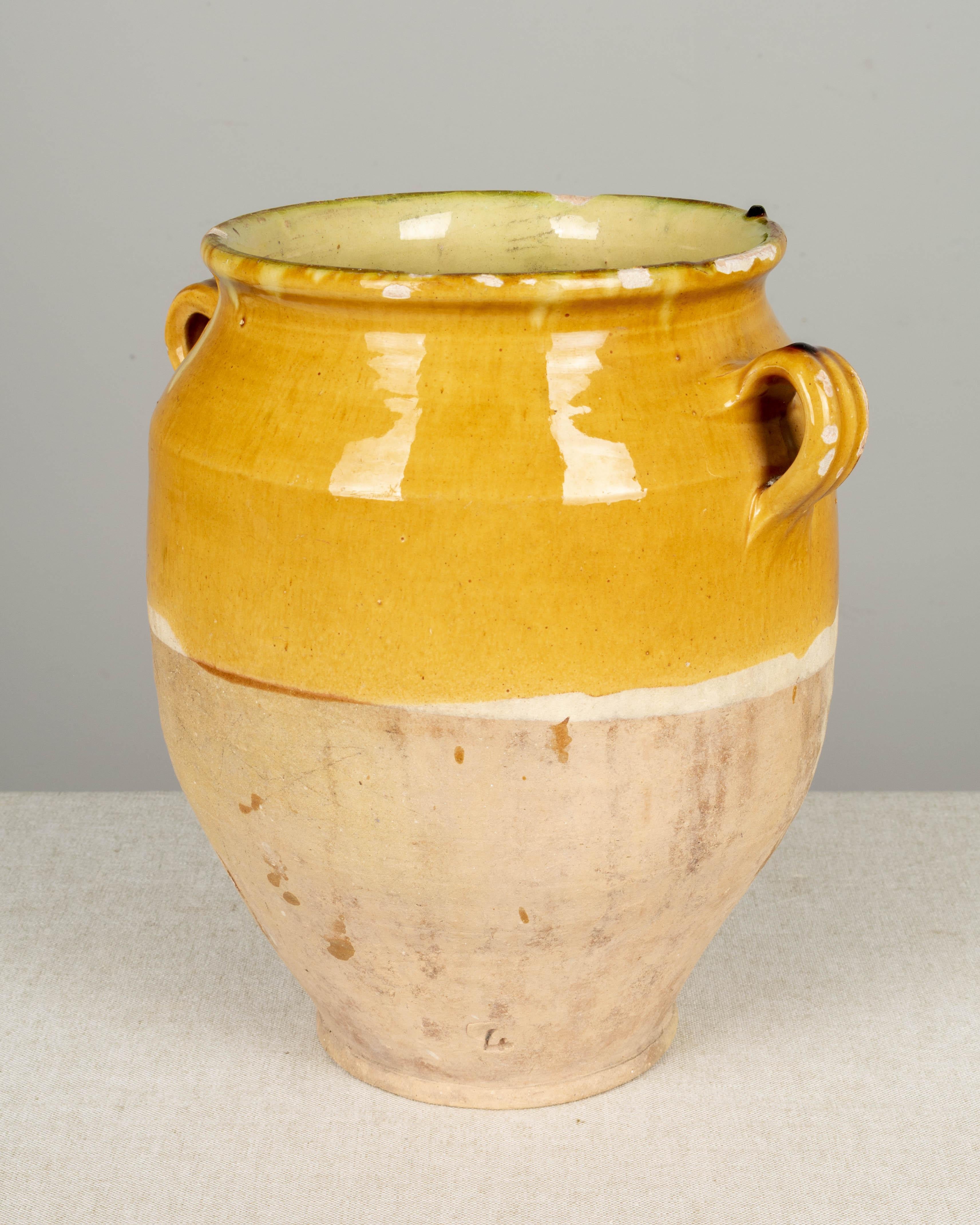 An earthenware confit pot from the Southwest of France with traditional yellow glaze. Some chips and losses to glaze. Weight: 6 lbs. These ordinary earthenware vessels were once used daily in the French country home and have beautiful rustic glazes