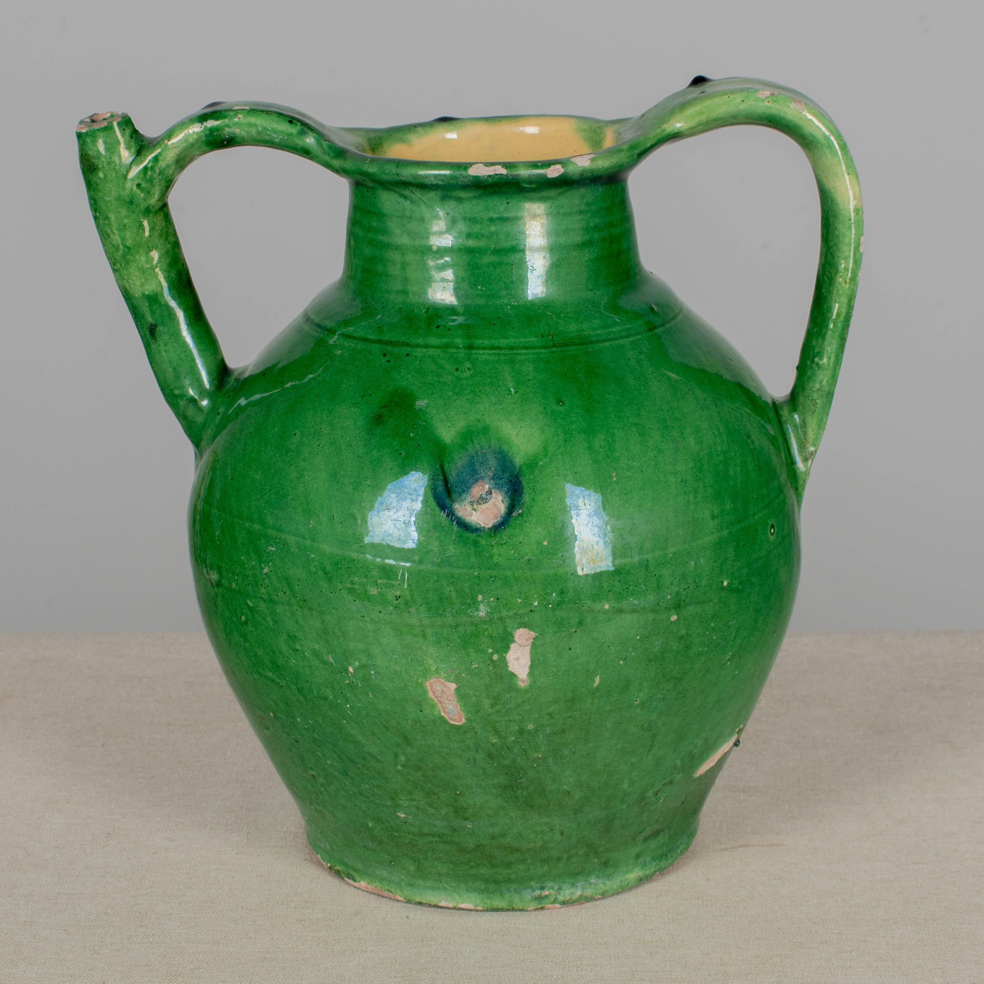 Brocca in terracotta smaltata verde dei primi del Novecento, proveniente dal sud-ovest della Francia, con beccuccio in uno dei manici. Un bel colore verde. Scheggiature e perdite sullo smalto. Circa anni '1900
Dimensioni: 11,5 