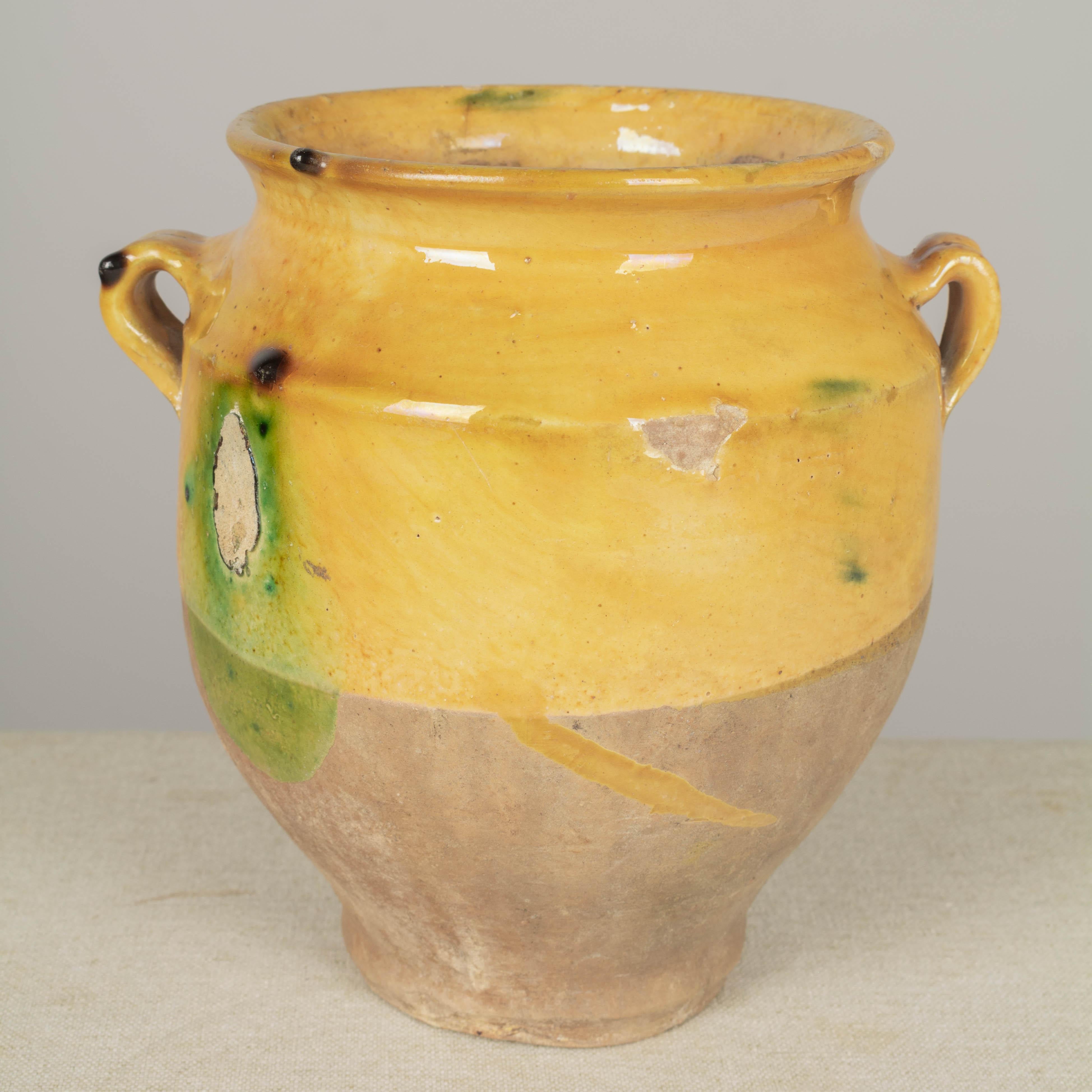 A small earthenware confit pot from the Southwest of France with traditional yellow ochre glaze with green drips. Minor chips and losses to glaze. These ordinary earthenware vessels were once used daily in the French country home and have beautiful