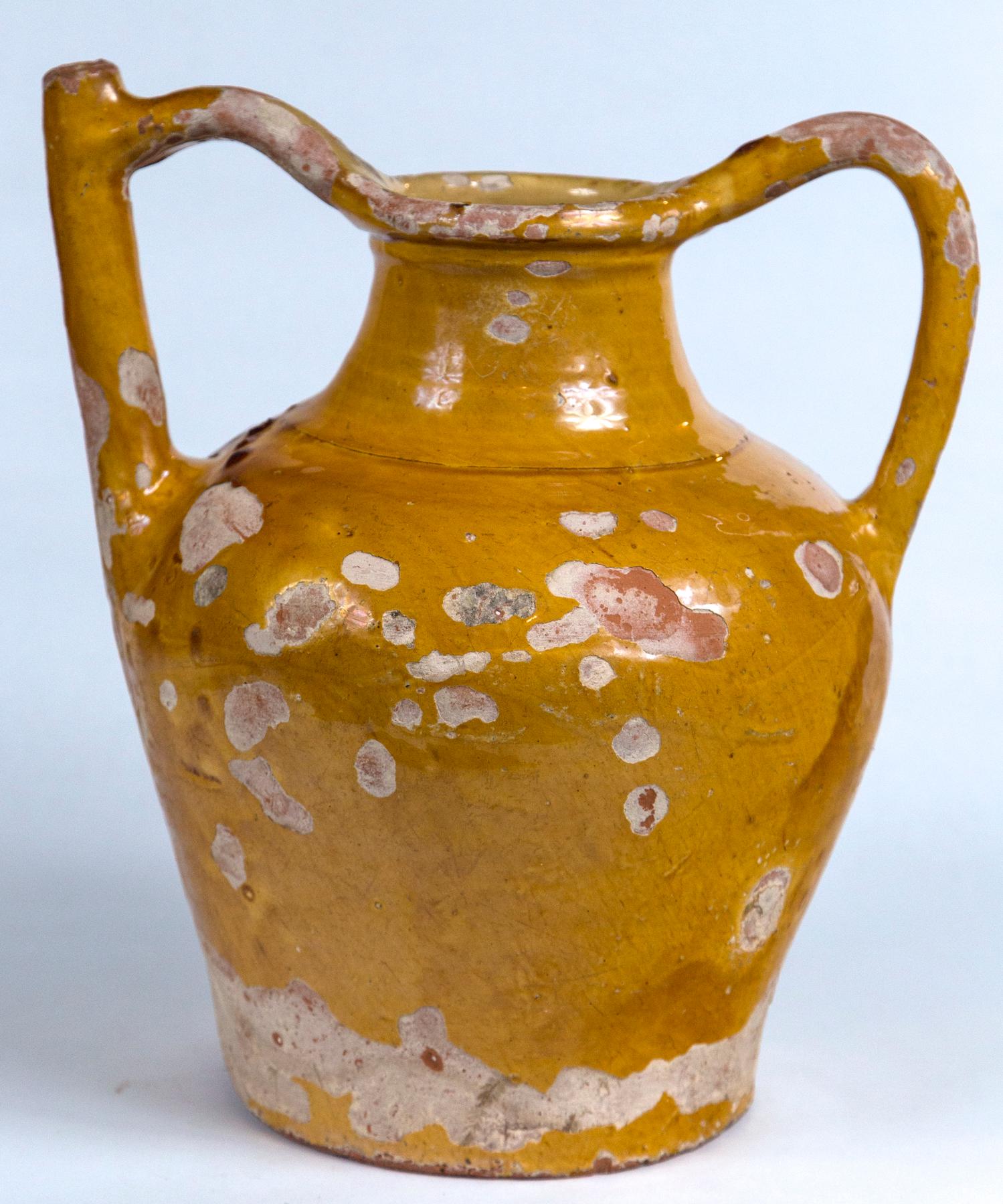 French terracotta water pitcher (Gargoulette), 19th century. A wonderful and rare piece of pottery. The double handled design was for serving water at the table. Traditional mustard yellow glaze on the exterior, paler yellow glaze on the interior.