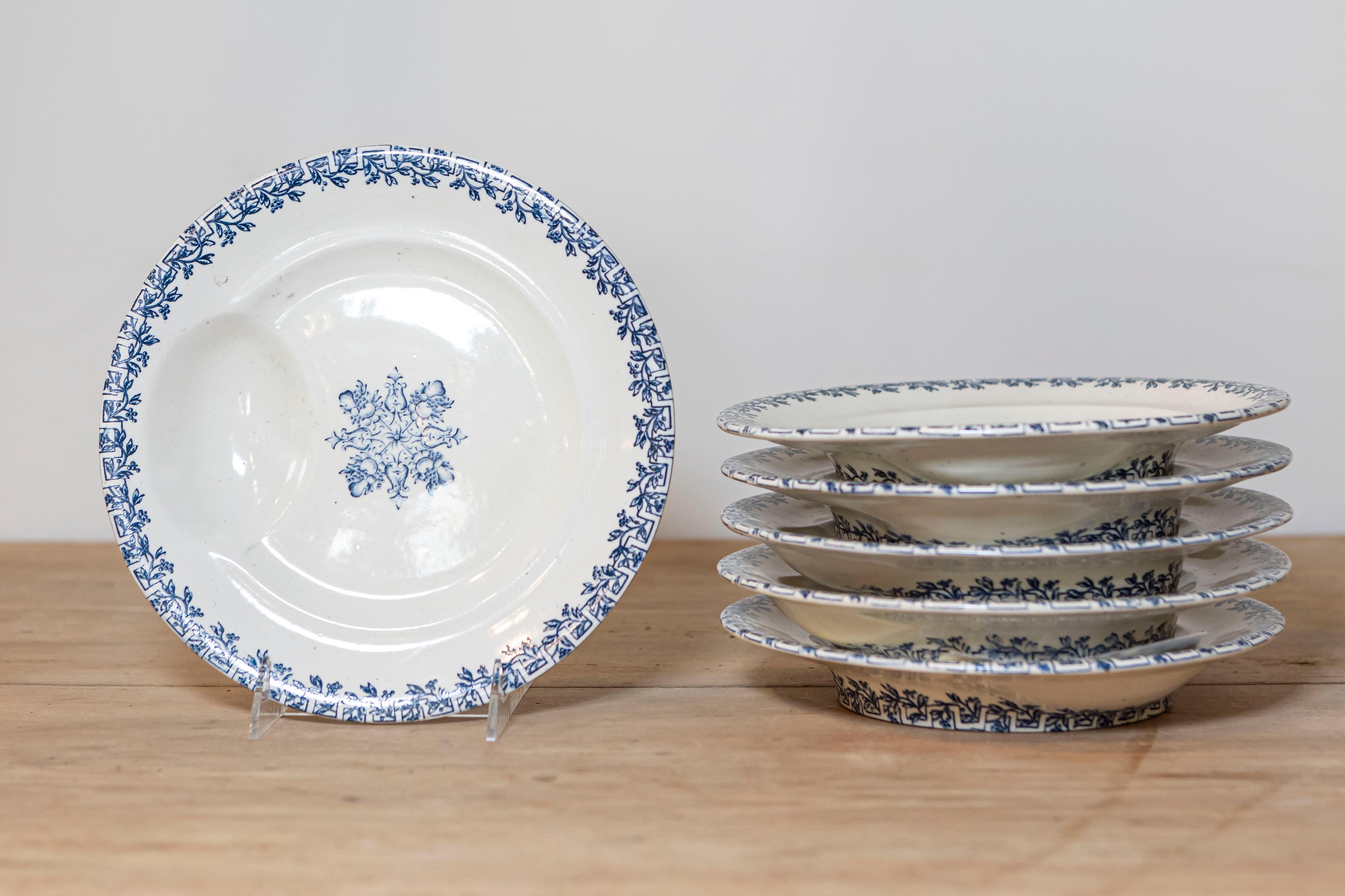 Six assiettes à asperges bleu et blanc Terre de Or du XIXe siècle, à décor de feuillages et de fruits, mises à prix et vendues à l'unité. Née en France au XIXe siècle, chacune de ces assiettes présente un décor de feuillages et de fruits bleus se