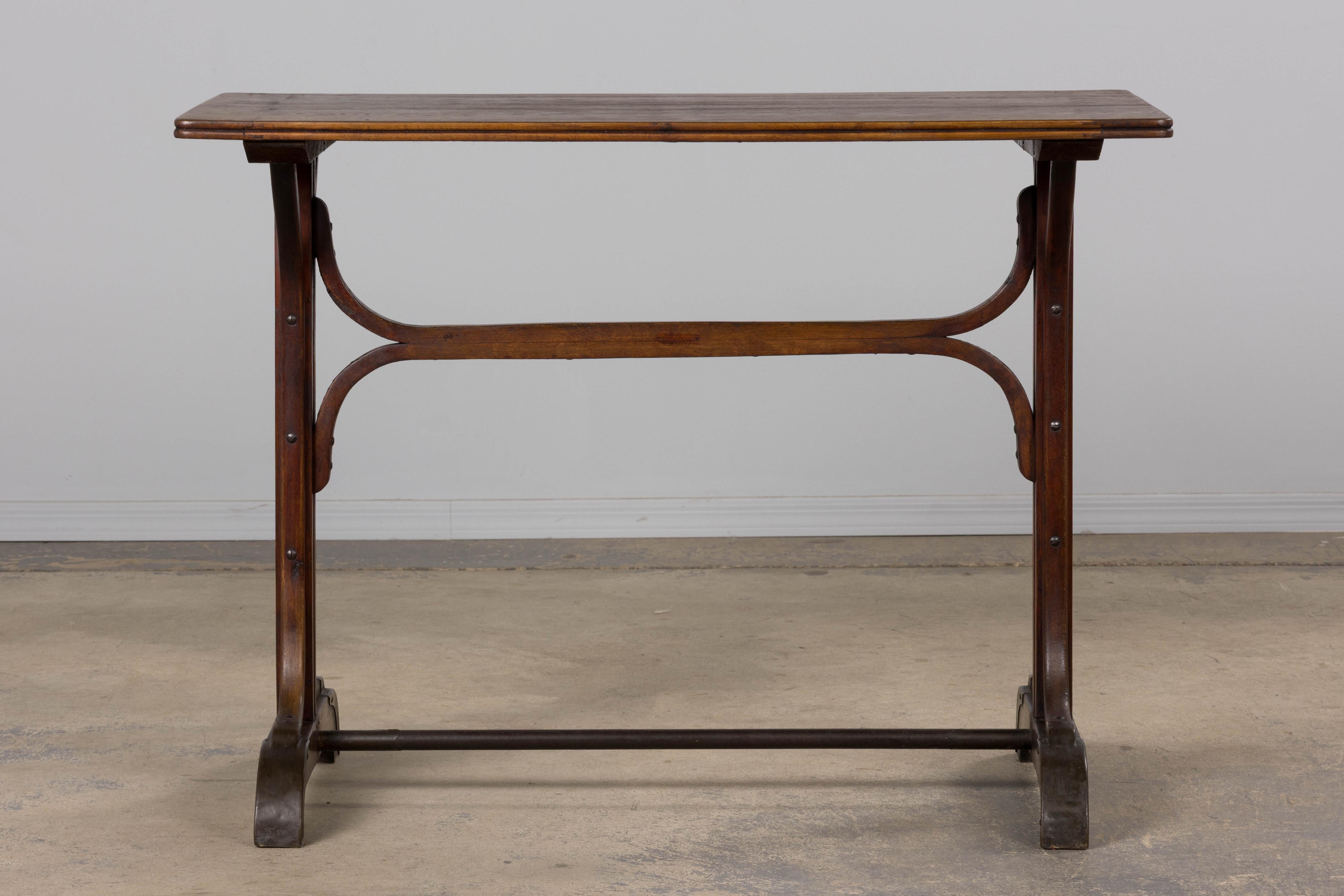 Une élégante table de bistrot française du début du 20e siècle dans le style Thonet, provenant de Provence, France. Fabriqué en bois massif avec des supports en bois gracieusement courbé et des pieds en forme montés avec des entretoises en fer, le