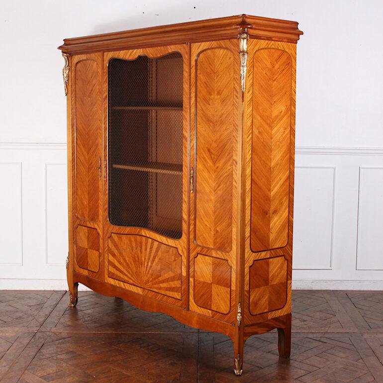 French three-door walnut Louis XV style bookcase with book-matched and banded veneer work throughout and a splendid ‘sunburst’ pattern to the centre door. Original gilt ‘grille’ mesh door and embellished with particularly finely-cast and finished