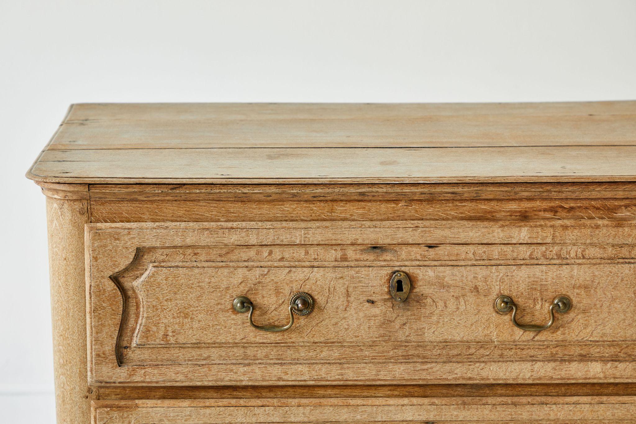 French oak three-drawer chest of drawer with scrolled details and original hardware. The finish is original and has not been altered.