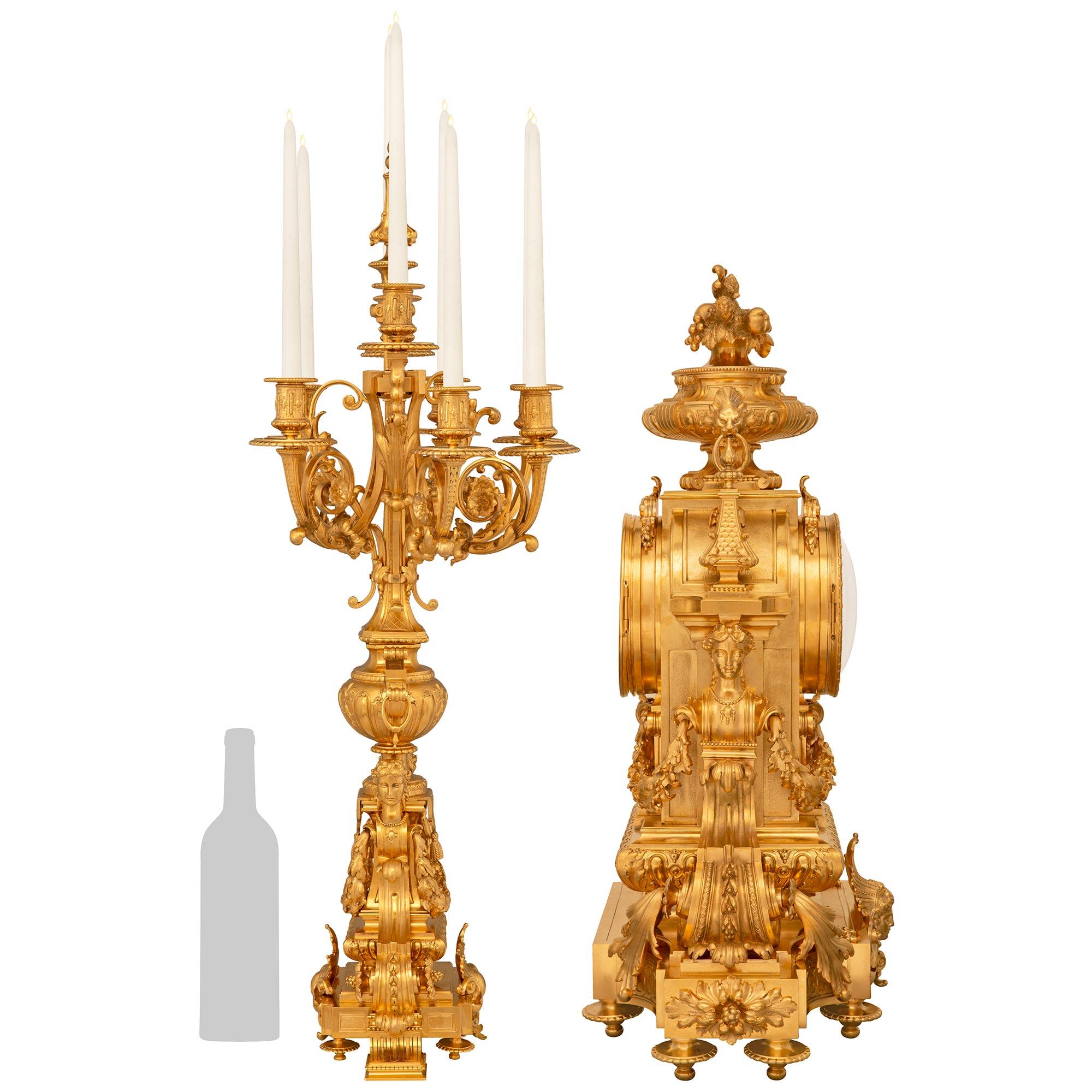 An extremely detailed and high quality French 19th century Regence st. Ormolu three piece garniture set, signed by the Lemerle-Charpentier foundry. This monumental garniture set consists of two candelabras and one clock. The clock is raised on a