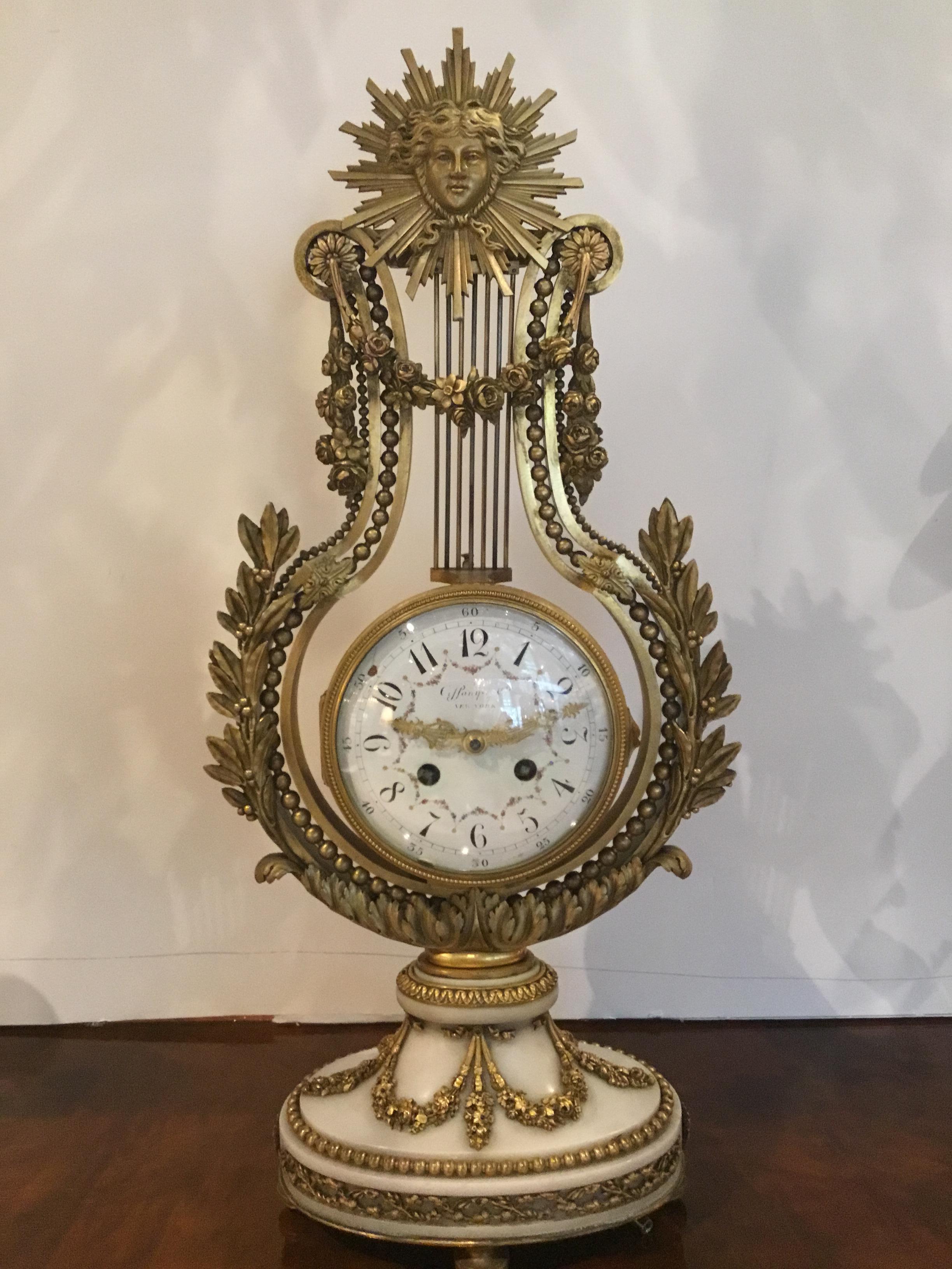 French White marble and bronze dore garniture set made for G J Payne
Co. New York, crafted by a Paris clock maker, 19th century. Set is comprised of
A clock with a gilt bronze mask draped with festoon swags. A lyre form frame
Surrounds the