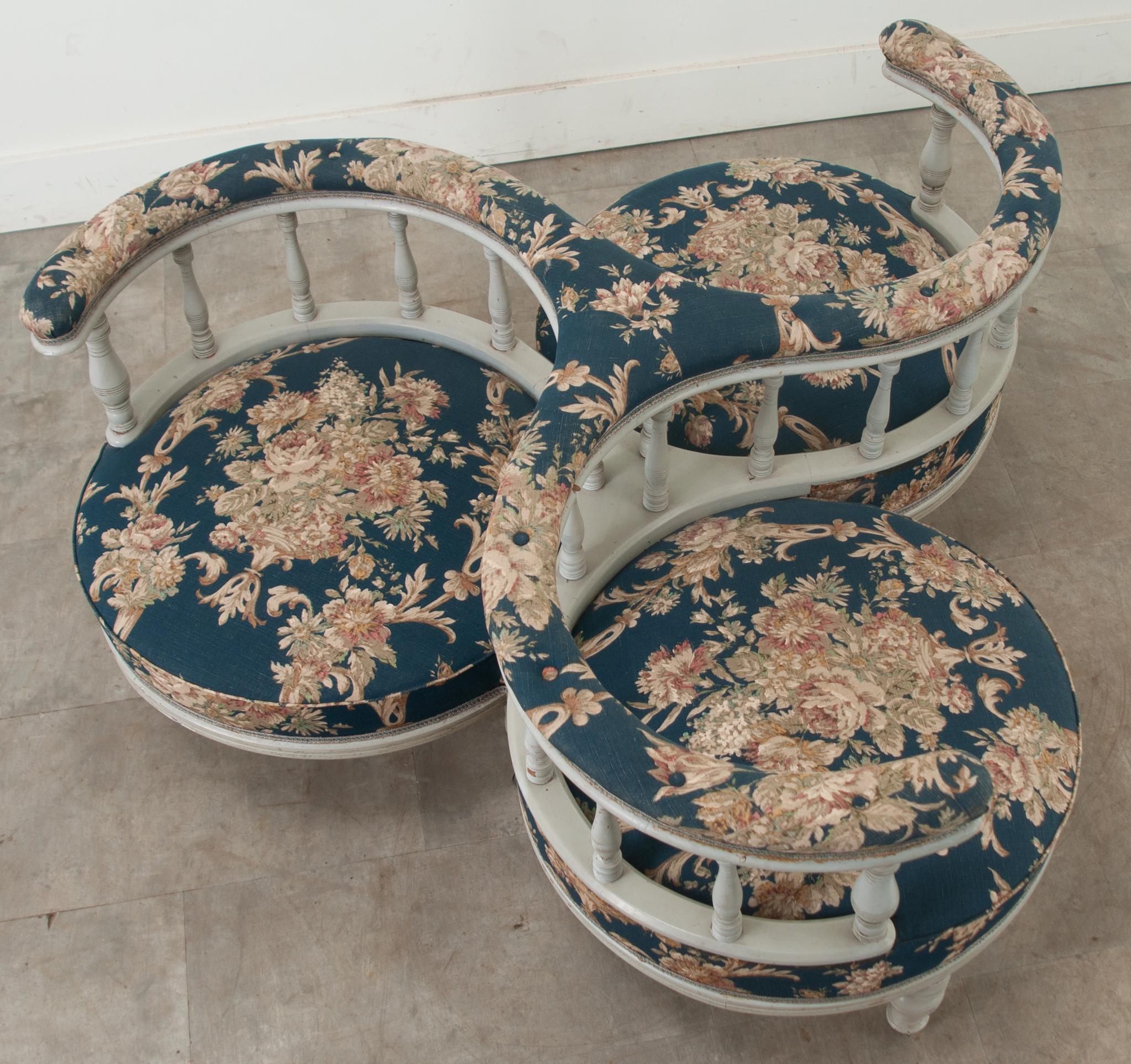 An interesting three-seat roundabout indiscret or conversation sofa. There are three curved upholstered and tufted arms on a painted baluster arcade. Over three round, boxed upholstered cushions with a floral pattern. The whole over six turned and