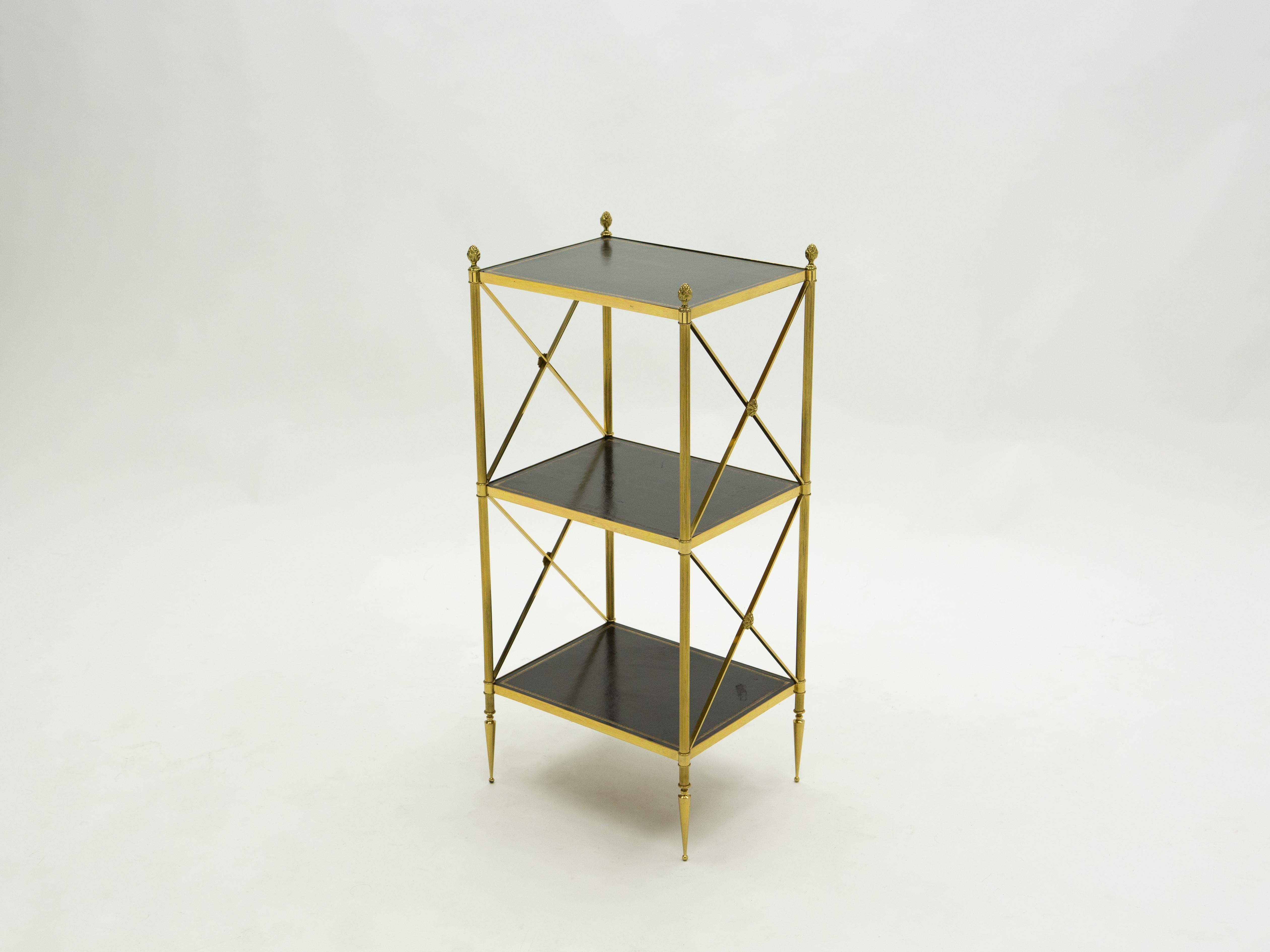 This beautiful three-tier side table by French design house Maison Jansen was created with solid brass, leather tops, and typical French neoclassical brass pine cones in the early 1970s. Its tapered feet, crossed side with brass flowers, and clean